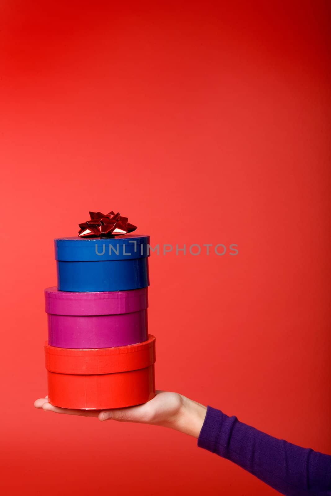 A stack of three gifts isolated on red with room for copy space