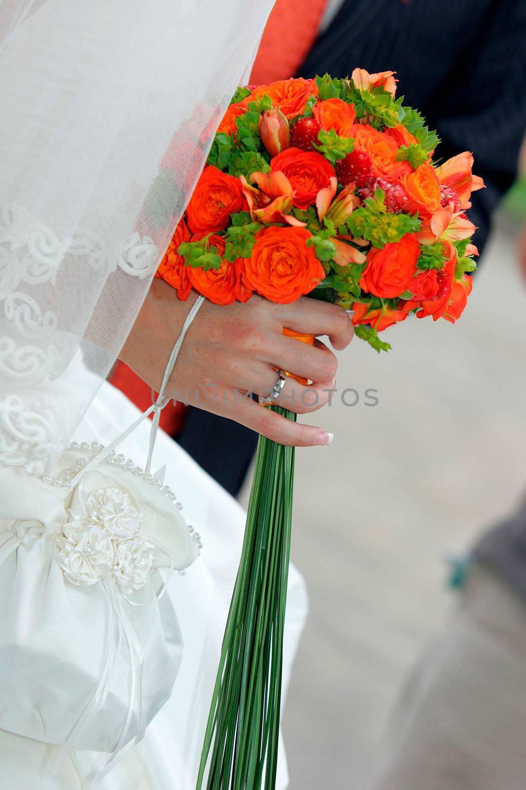 Close up portrait of bride in traditional white wedding dress holding a bouquet of flowers.