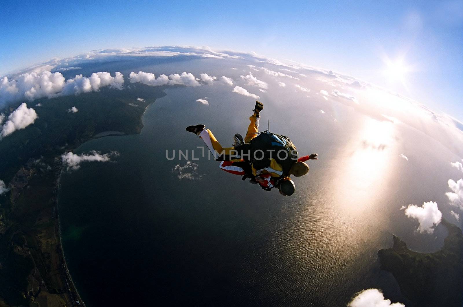 Portrait of two tandem skydivers in action parachuting through the air.