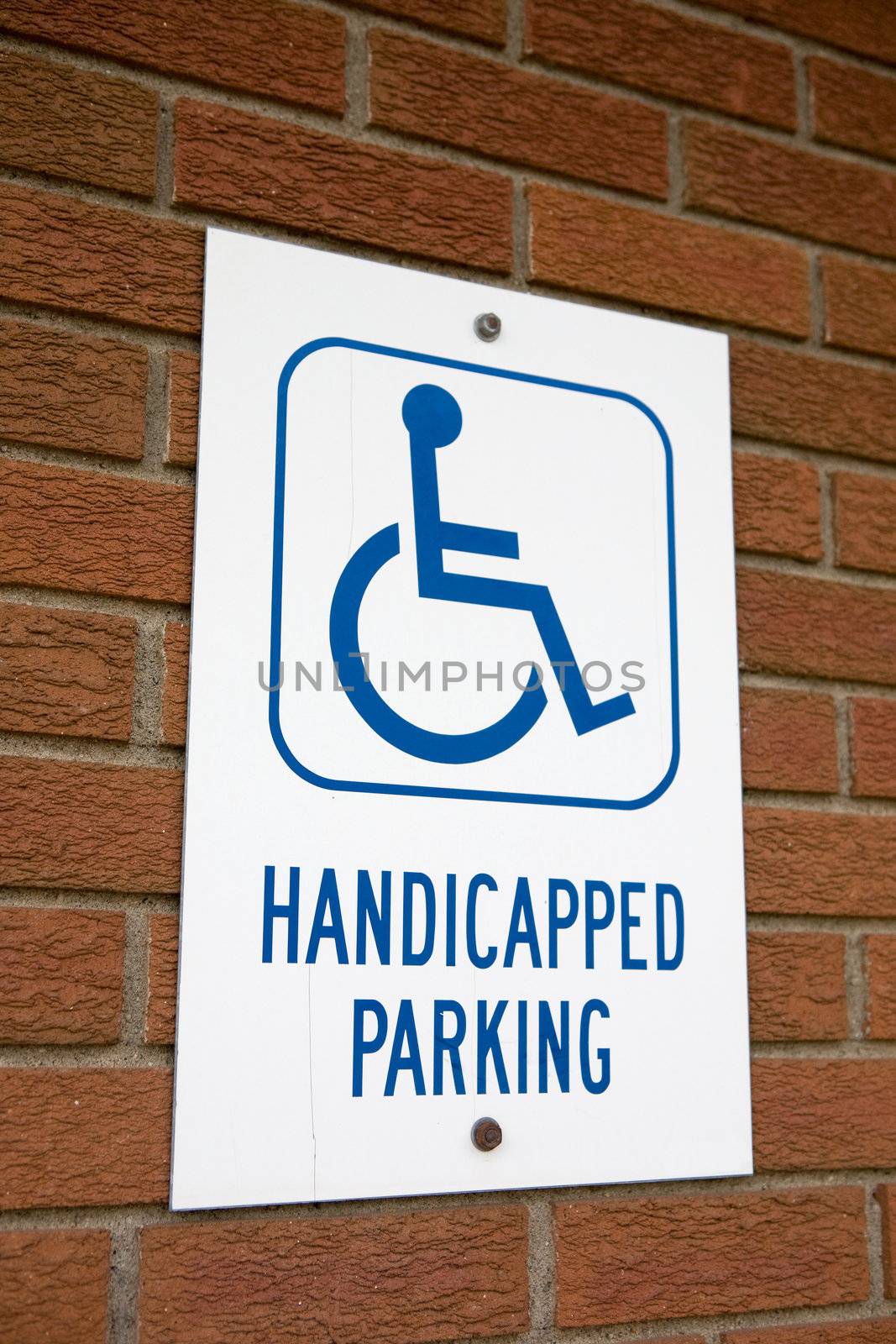 A handicapped parking sign on a brick wall