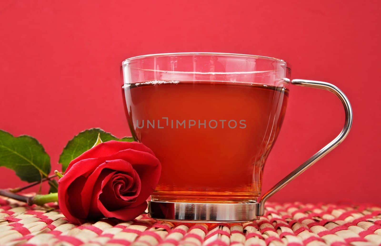 cup of tea with a rose, red background