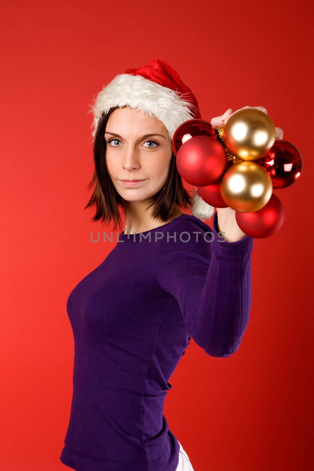 A young female holding up christmas decorations