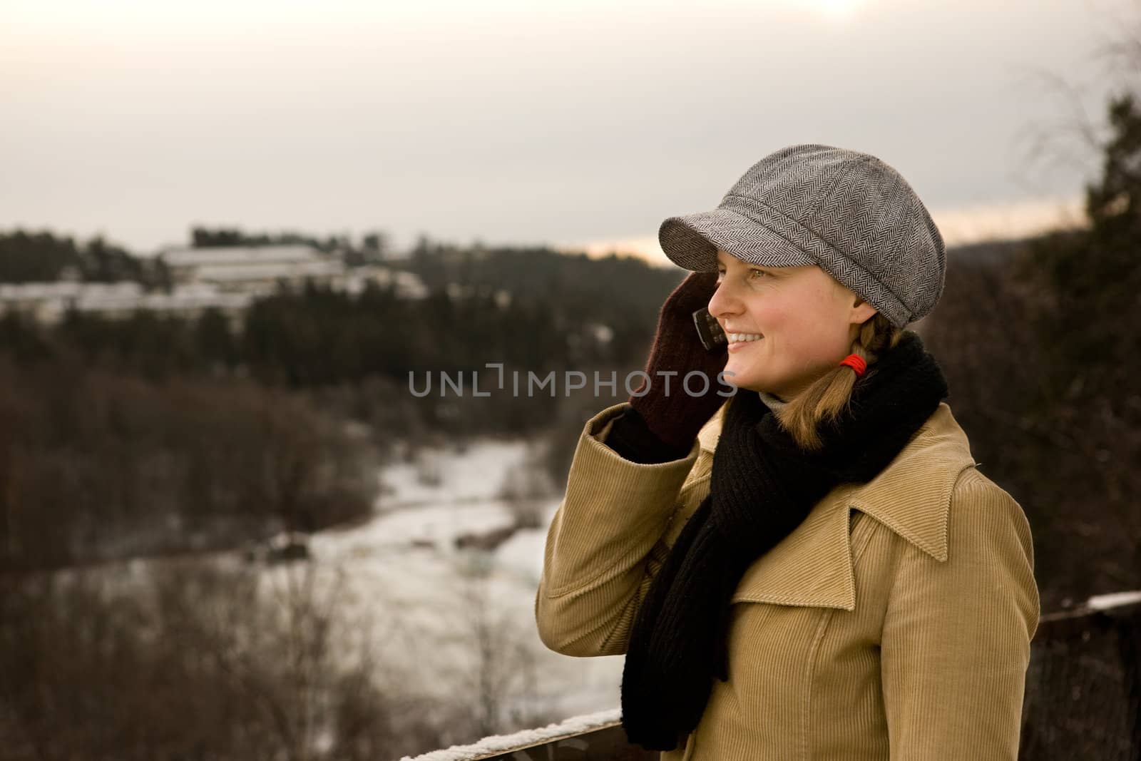 A young woman outside in winter talking on a cell phone