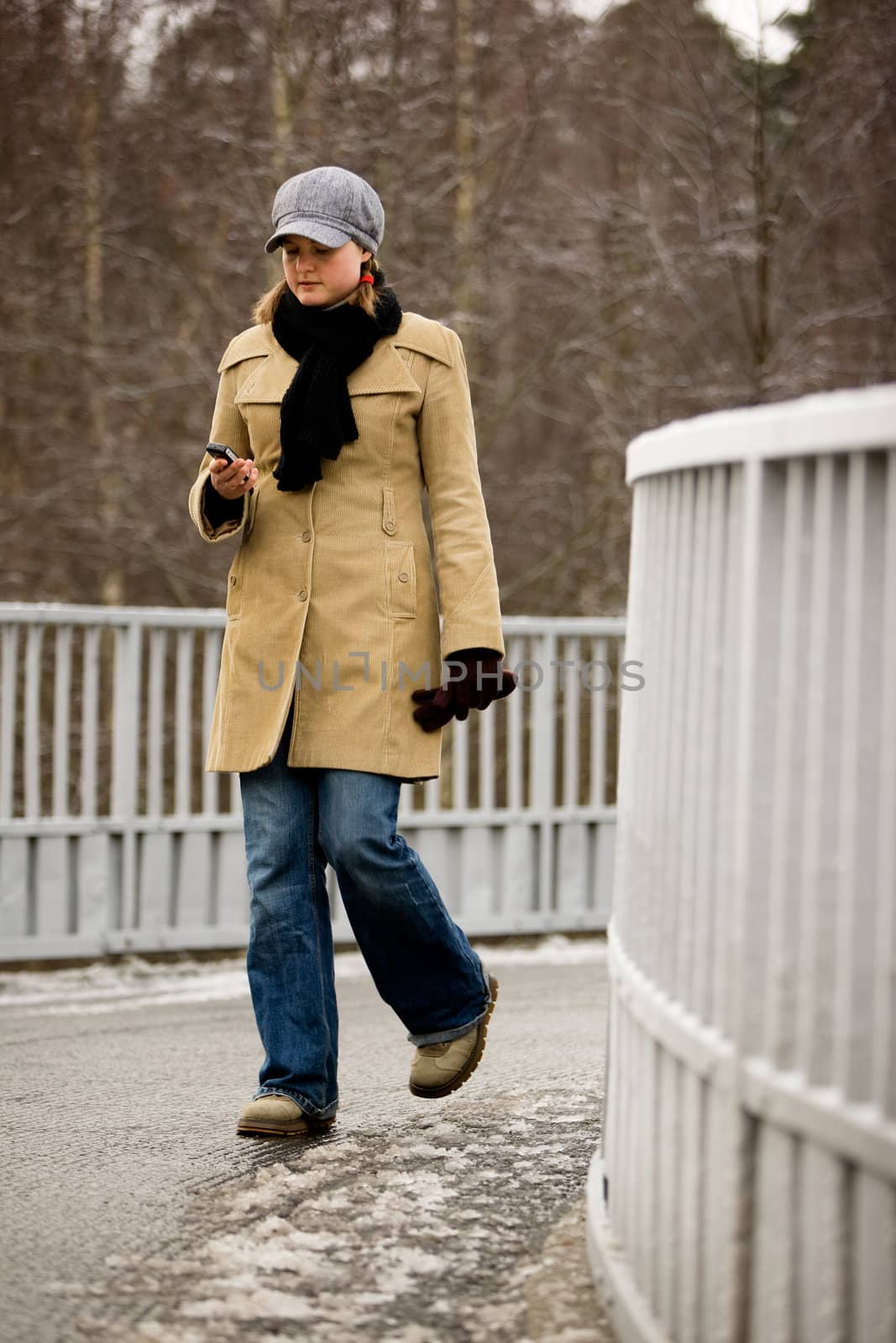 A young woman outside in winter user a cell phone
