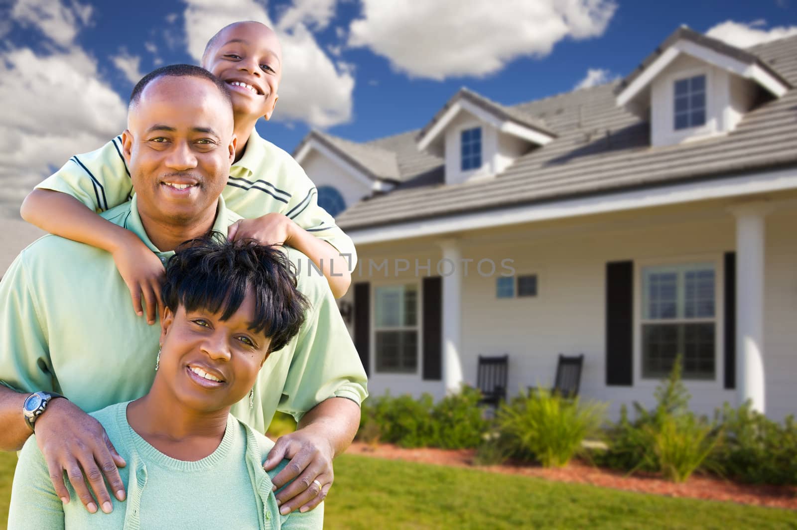 Attractive African American Family in Front of Beautiful House.