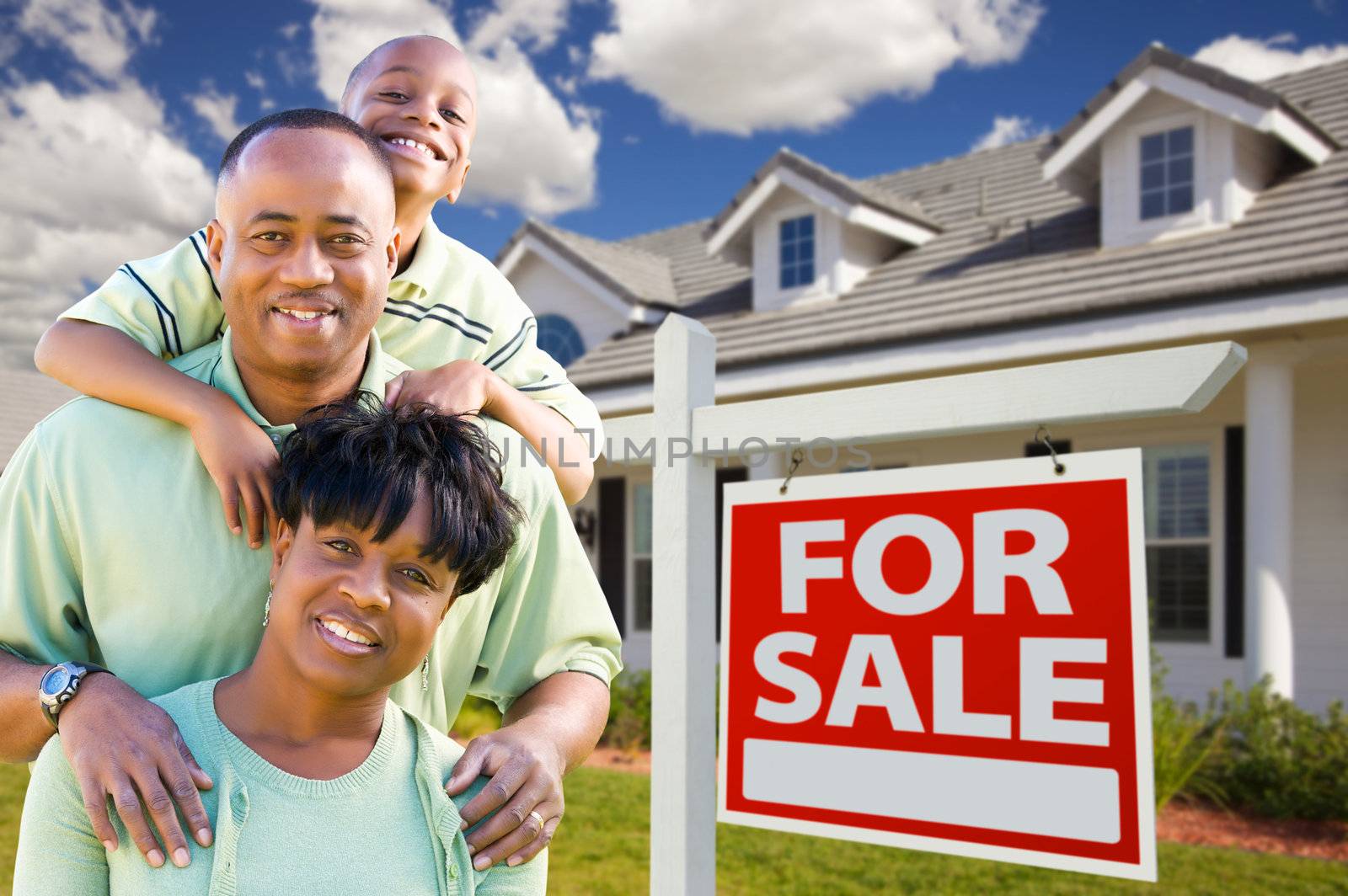 Happy and Attractive African American Family with For Sale Real Estate Sign and House.