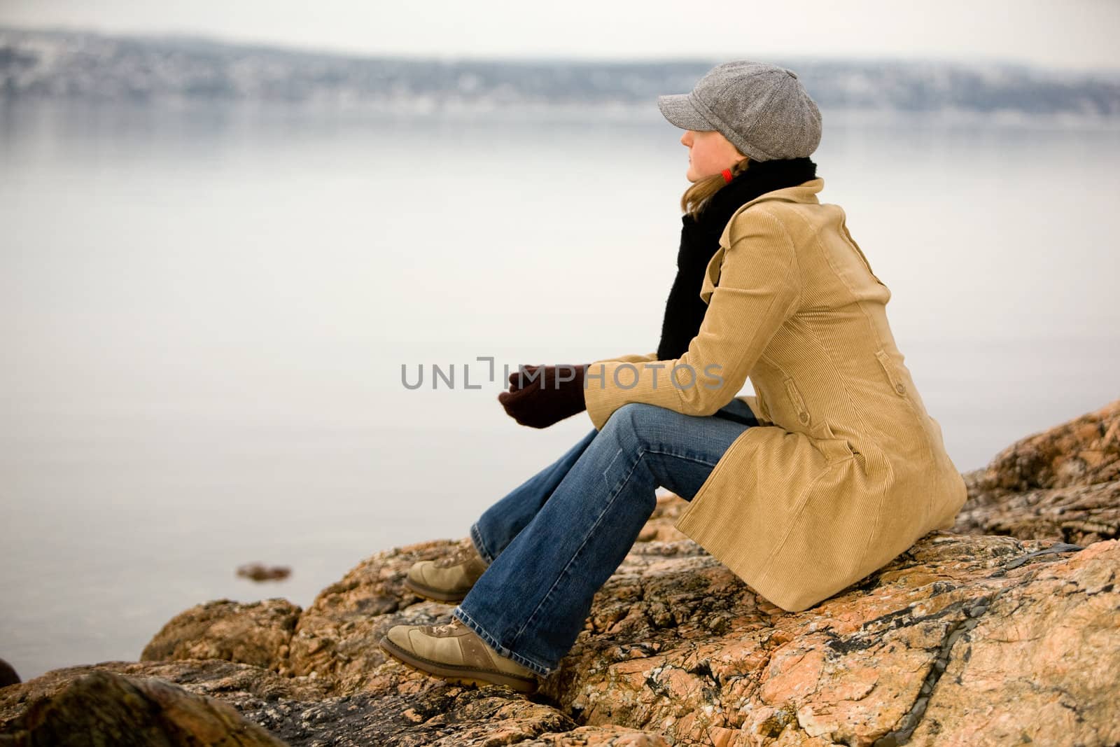 A young woman sitting by the ocean