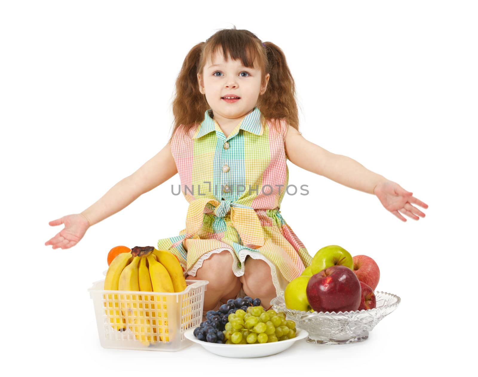 A little girl with a big heap of different fruits on white background