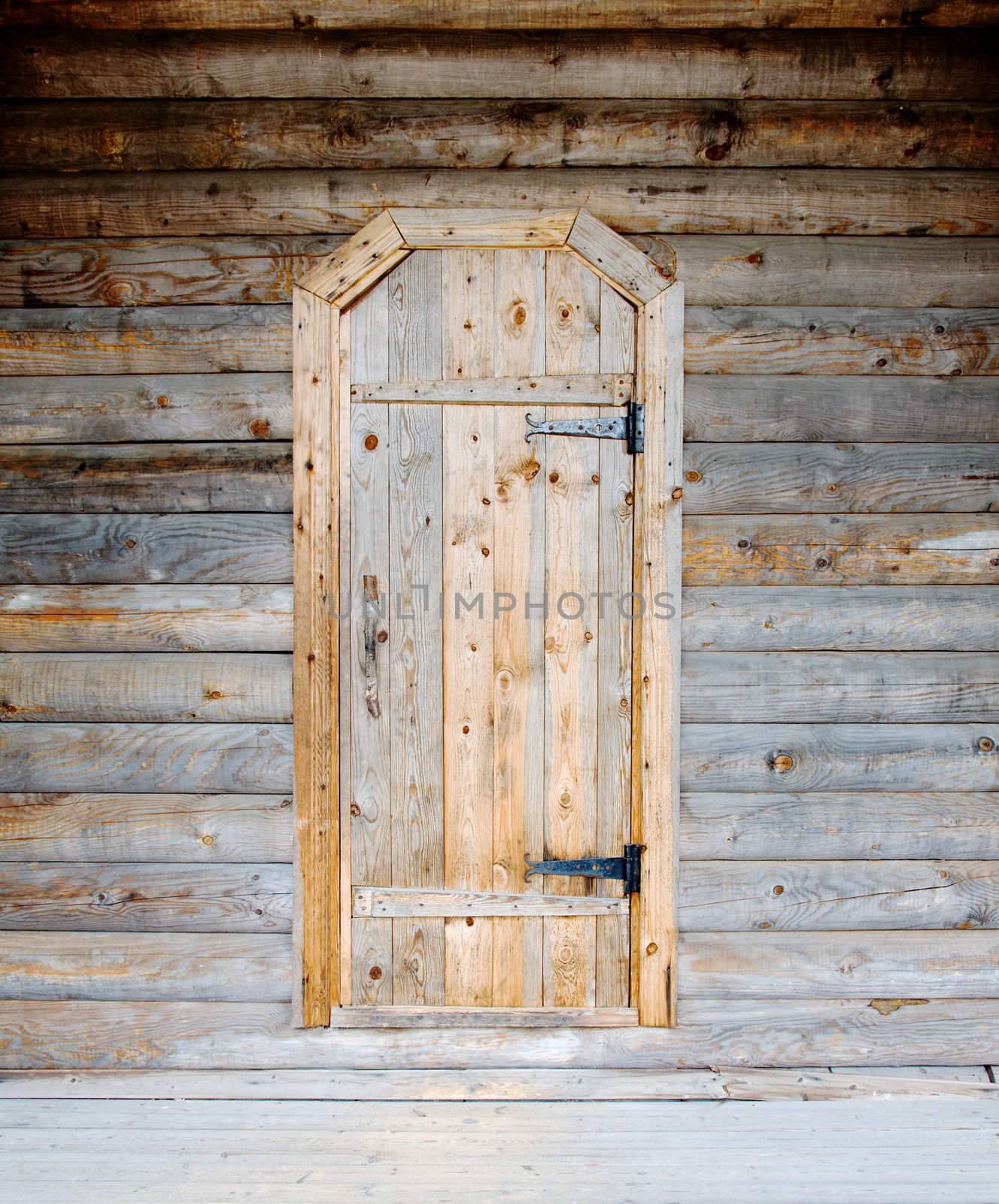 Old-fashioned rural wooden door on a timbered wall