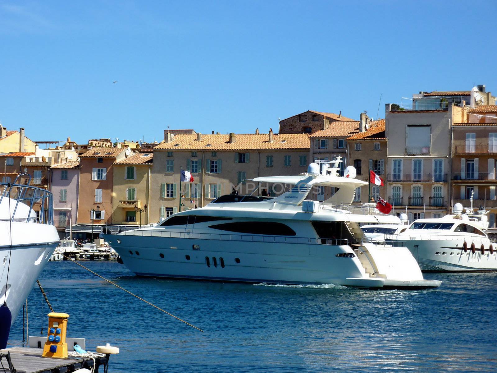 Big white yacht leaving Saint-Tropez port on Mediterrenean sea, south of France