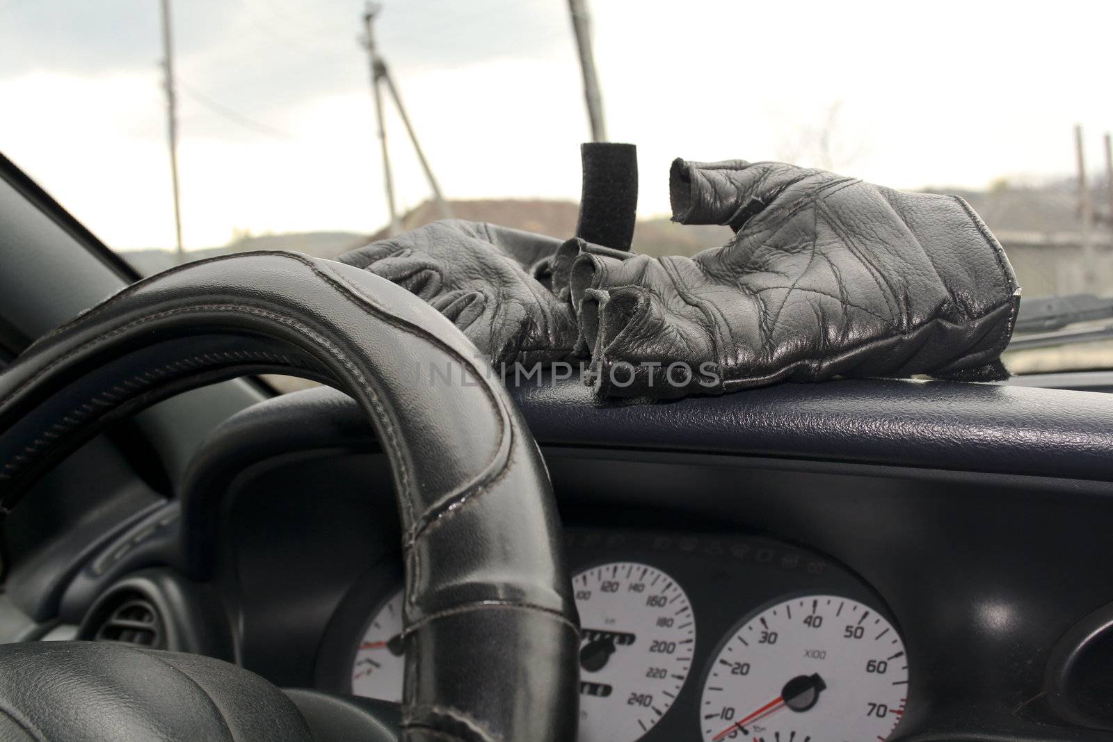 Leather gloves in torpedo cars, steerinf wheel, speedometer