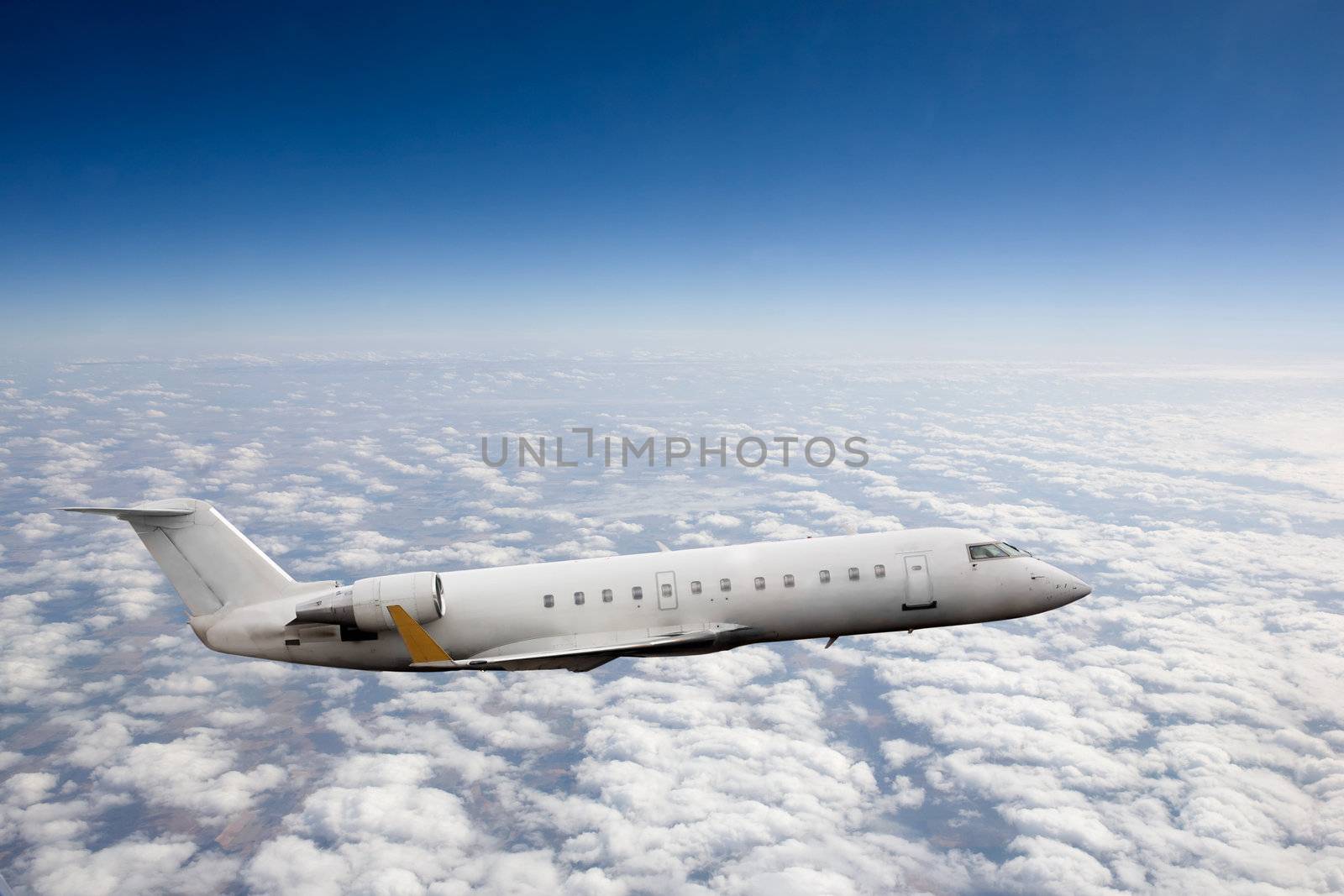 Airplane in flight over high altitude clouds