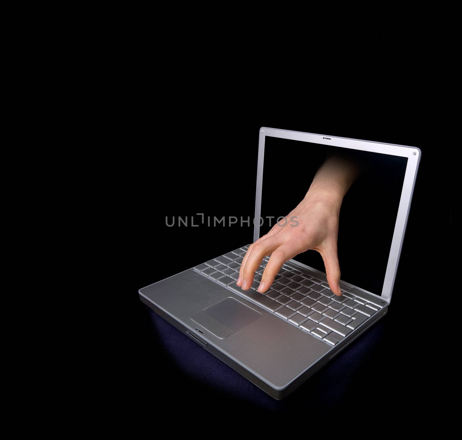 A hacker concept image of a hand coming through the computer.