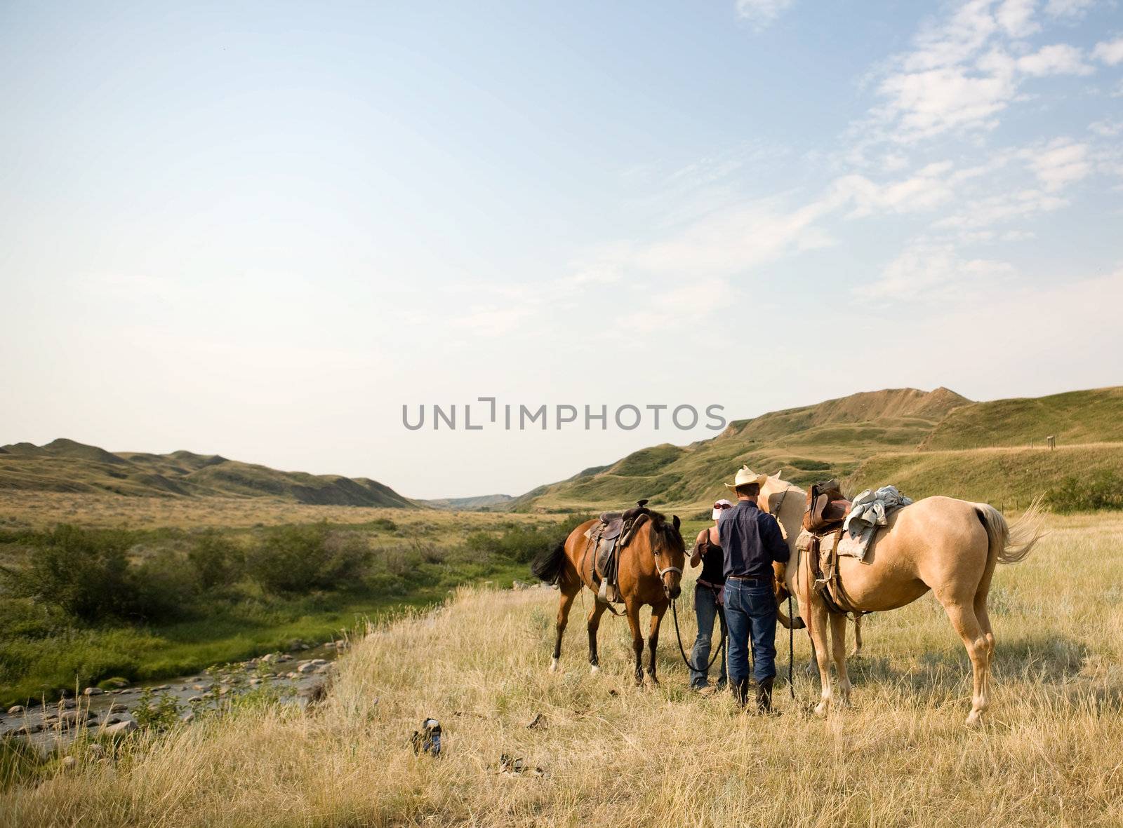 A couple of people ready to go on a ride accross rolling prairie hills