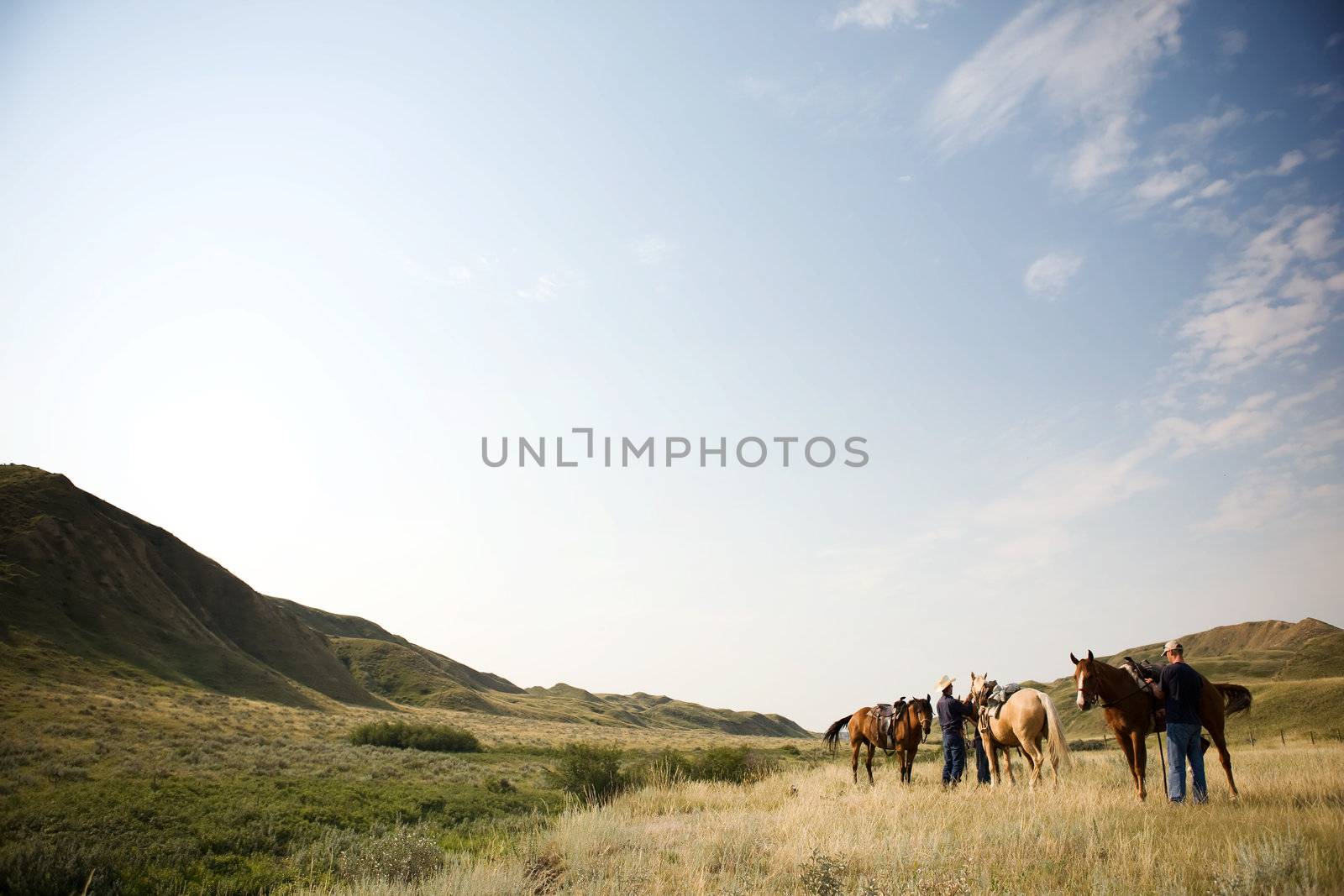 A couple of people ready to go on a ride accross rolling prairie hills