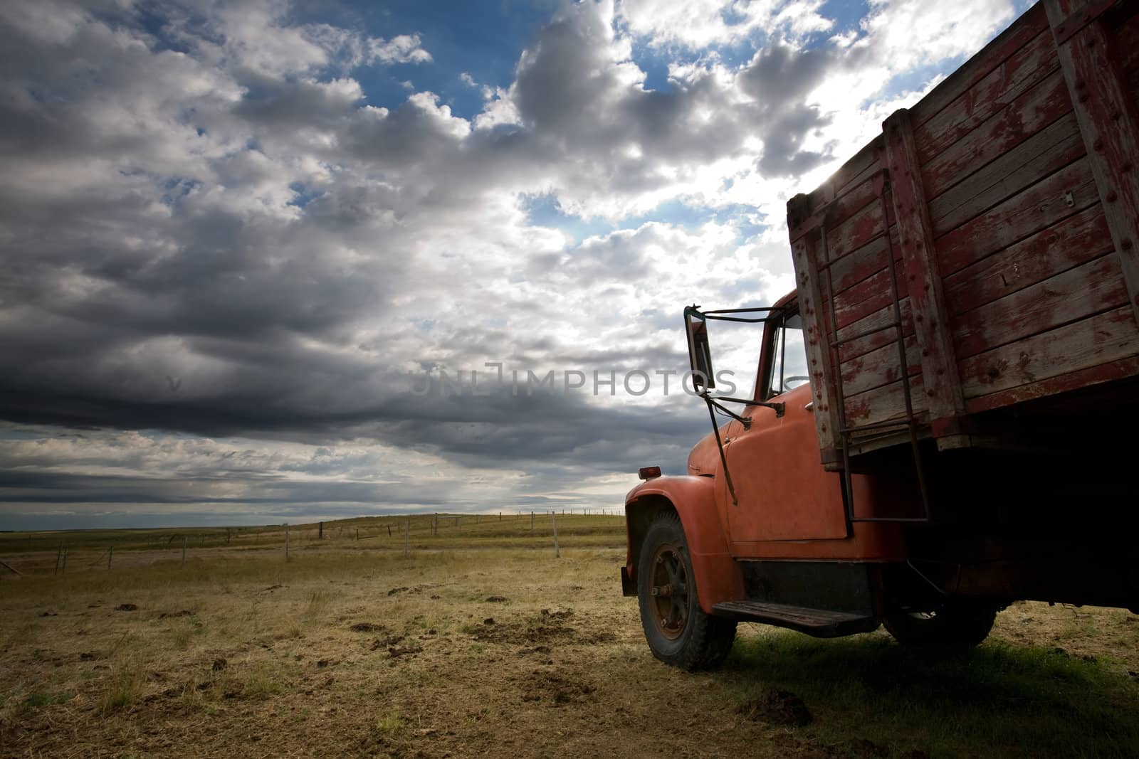 An old farm truck against a dramatic prairie landscape