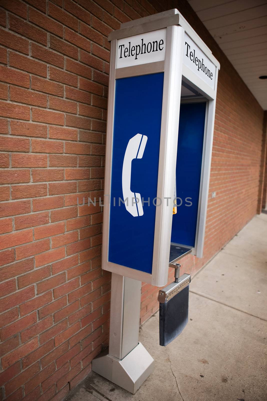 A pay phone against the side of a brick building