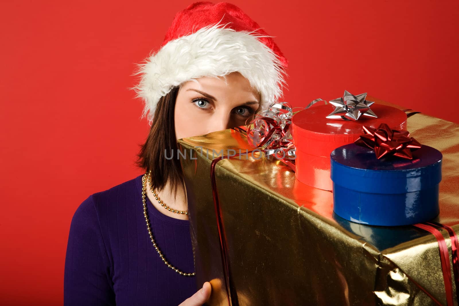 A young woman with a present isolated on red