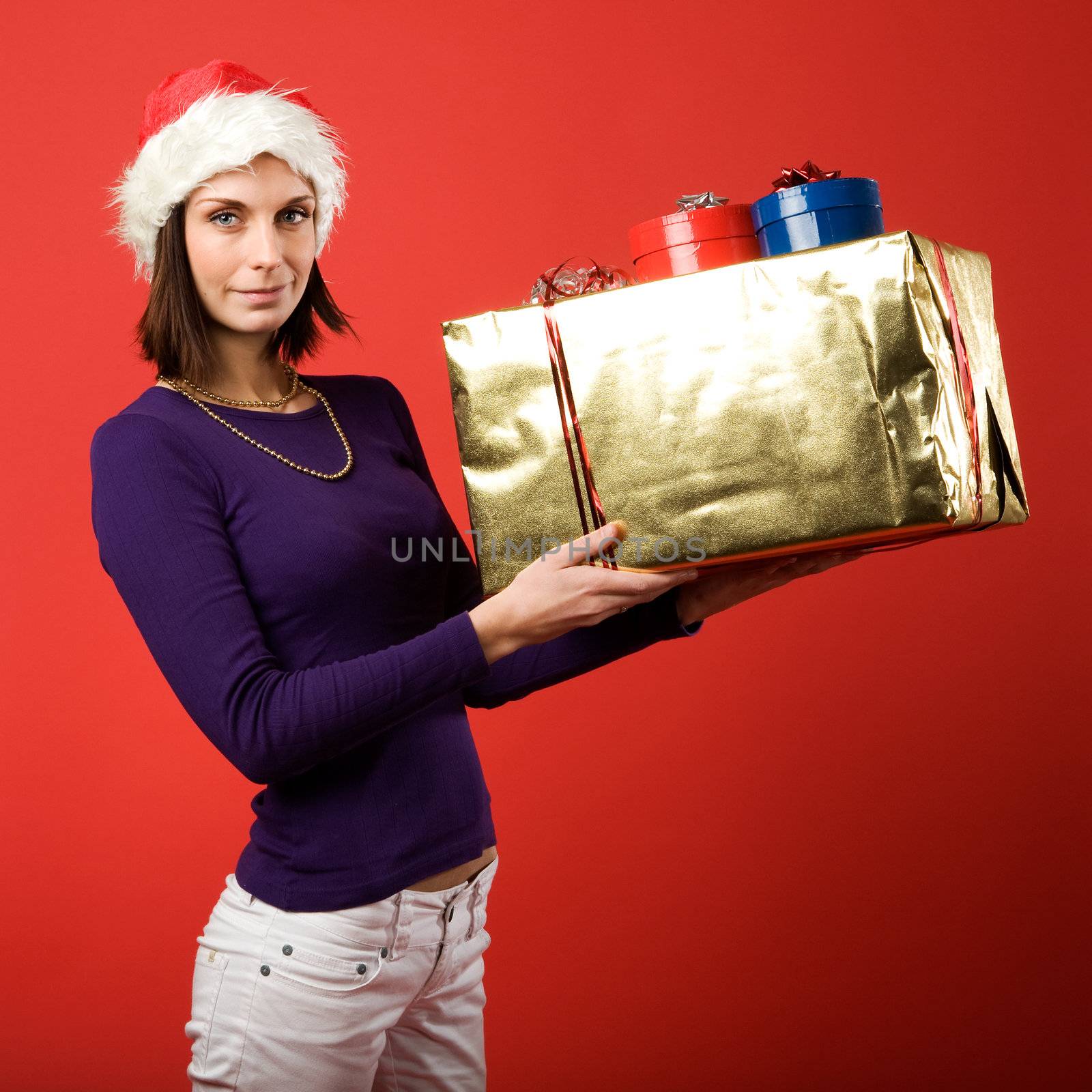 A young woman with a present isolated on red