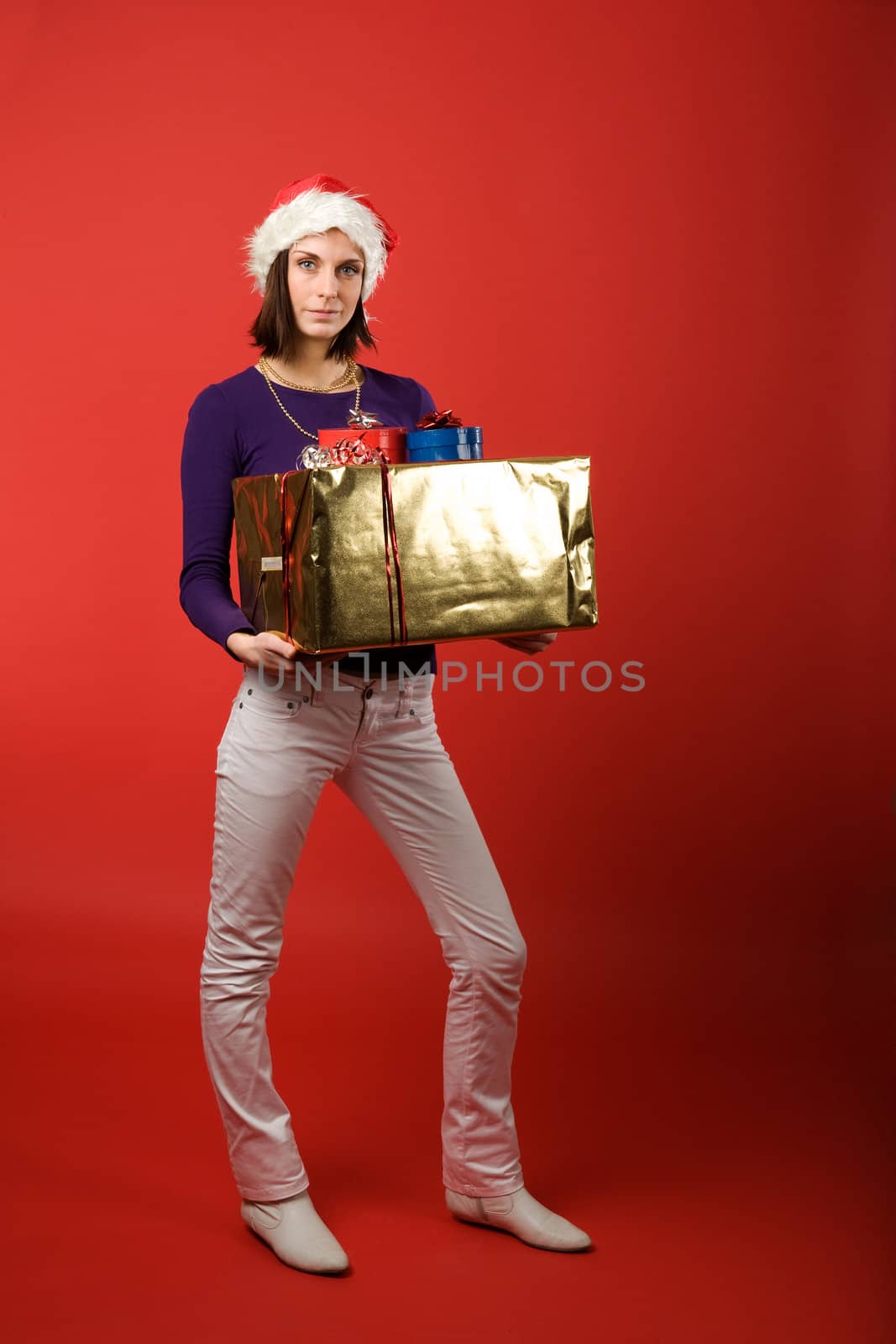 A young woman with a present isolated on red