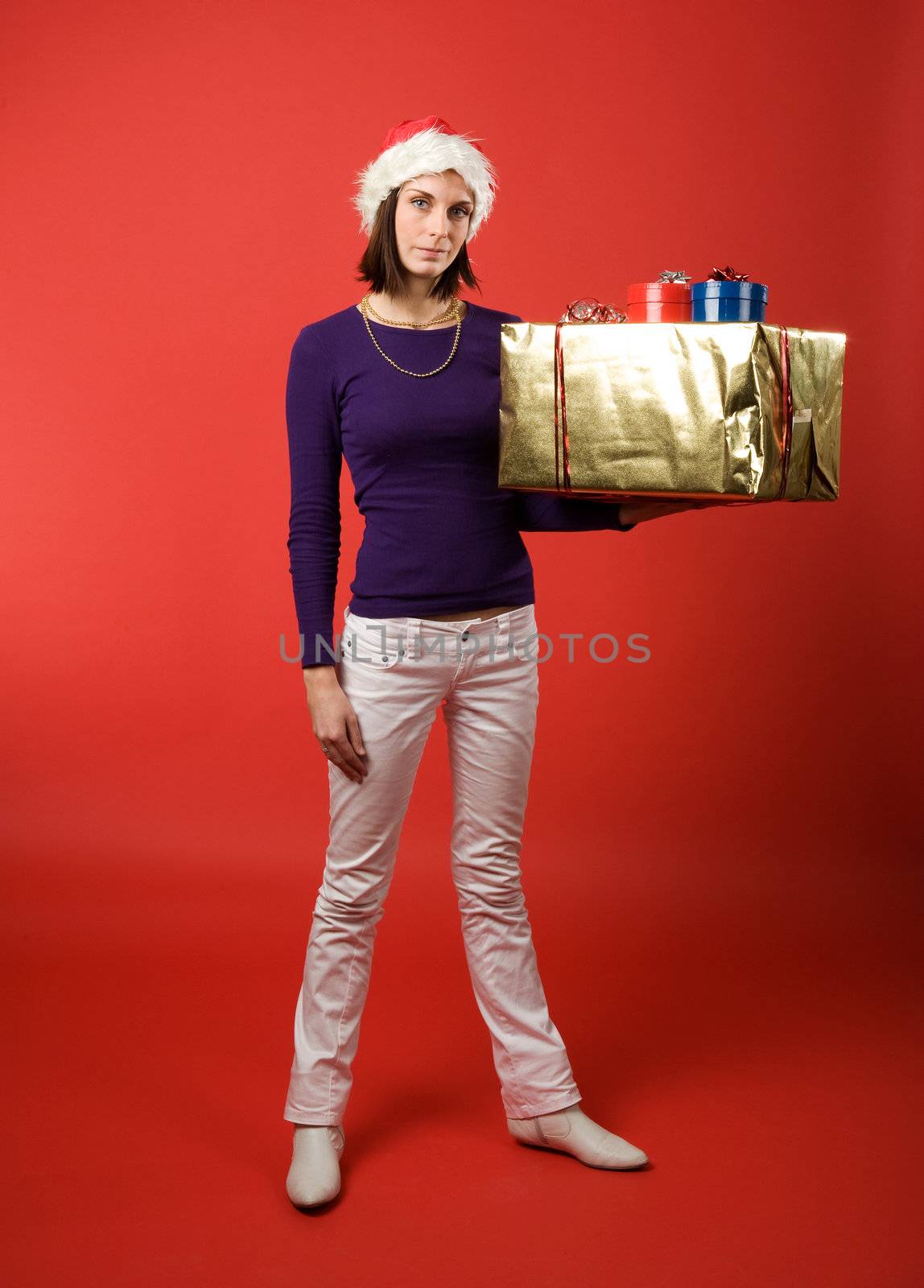 A young woman with a present isolated on red