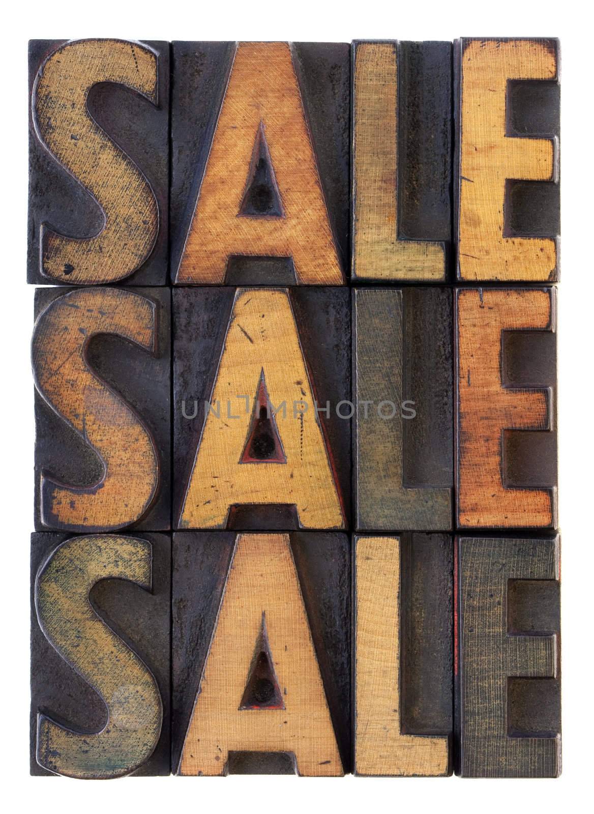 the word sale (three versions) in vintage wooden letterpress type, stained by ink, isolated on white