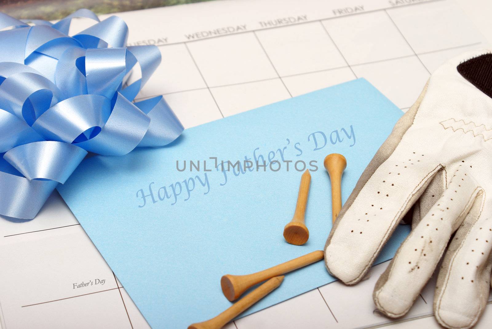 A card for father lays on a calendar with other accesories for the celebration.