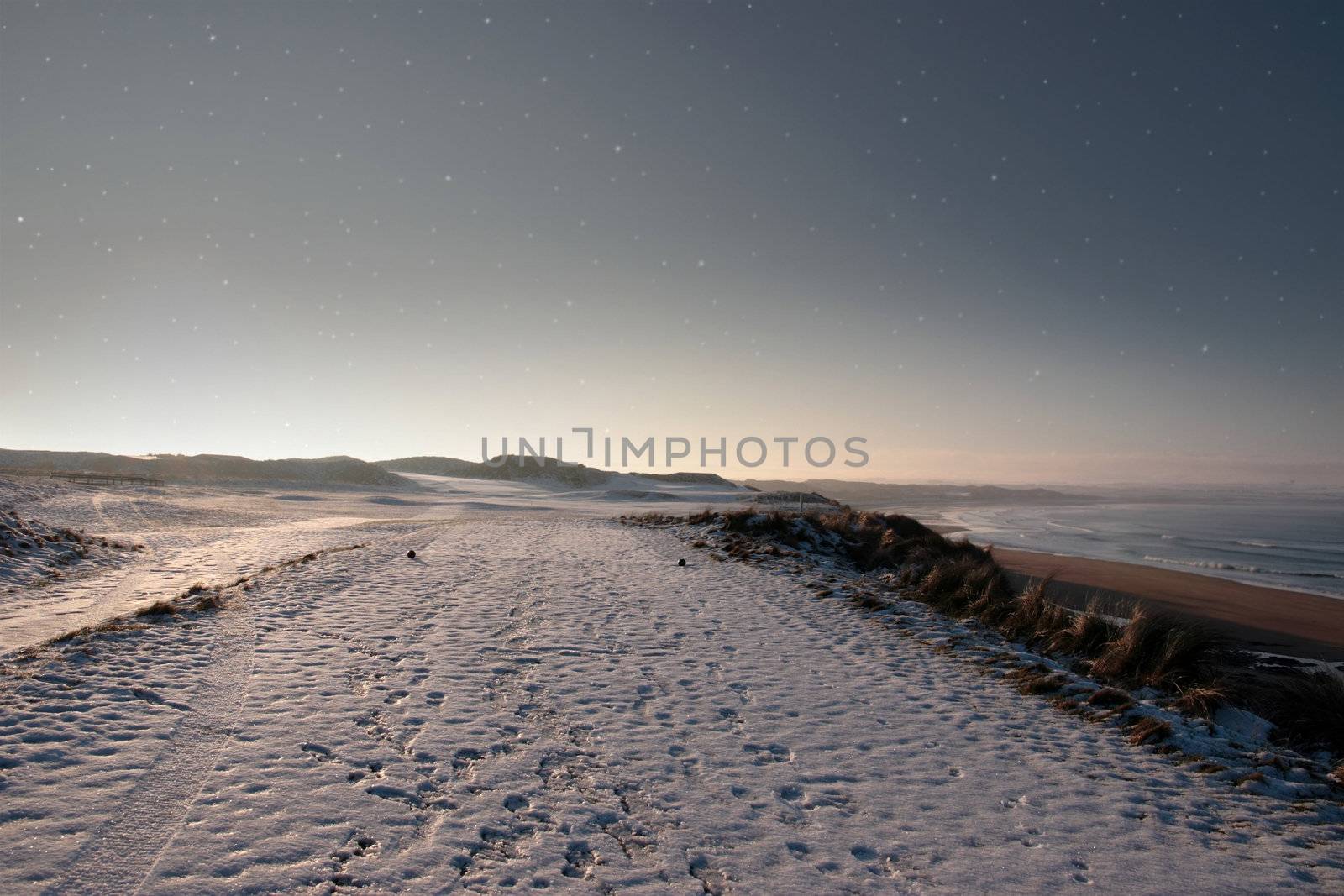 snow covering on a golf course in ireland in winter with stary night sky