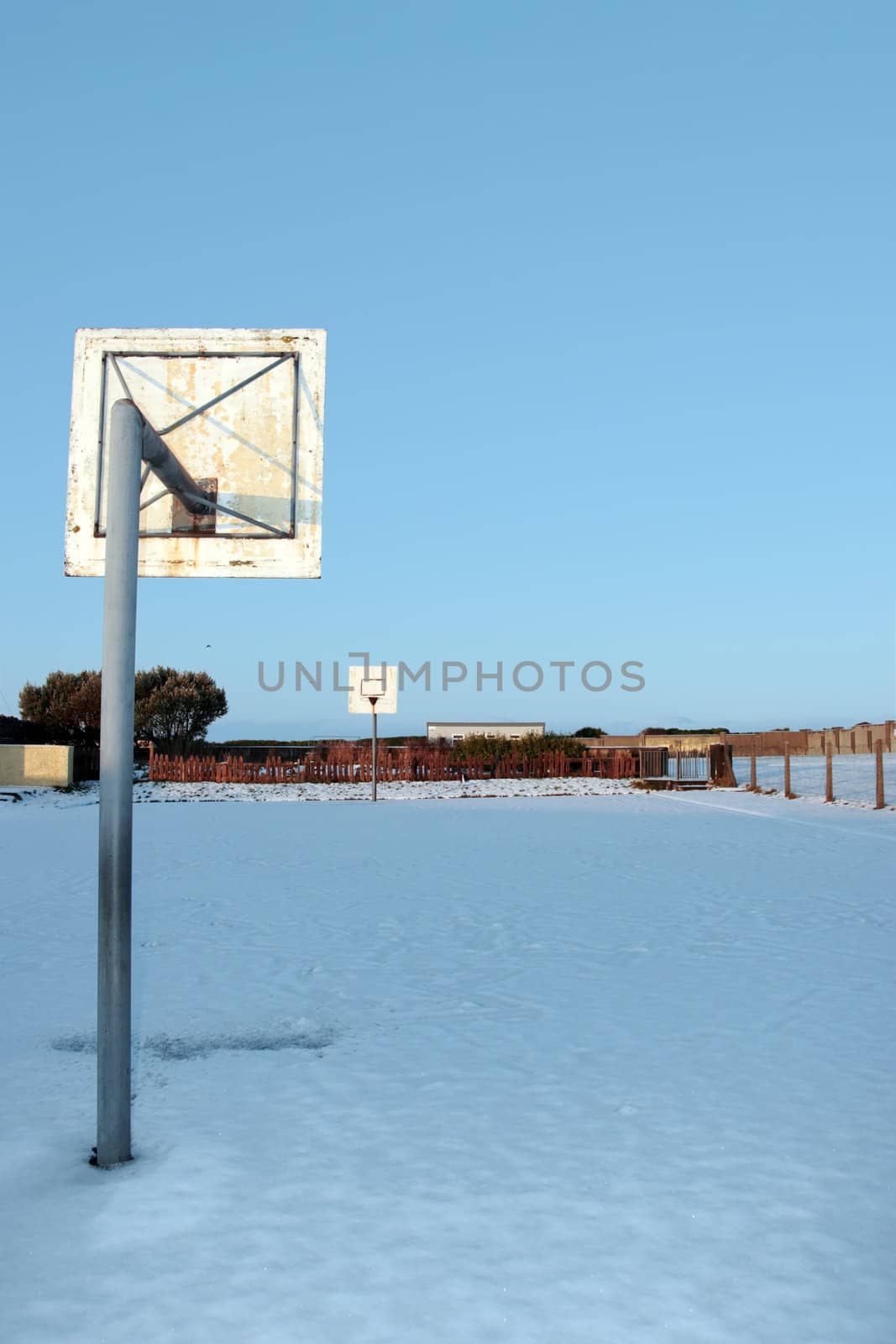 a snow covered school playground basketball court