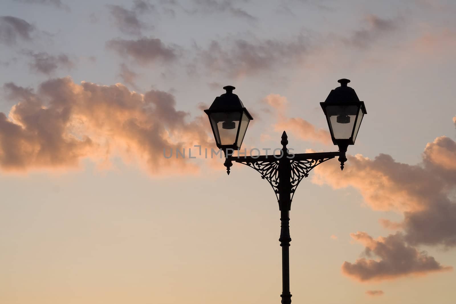 Silhouette of street lamp on sky background in sunset time