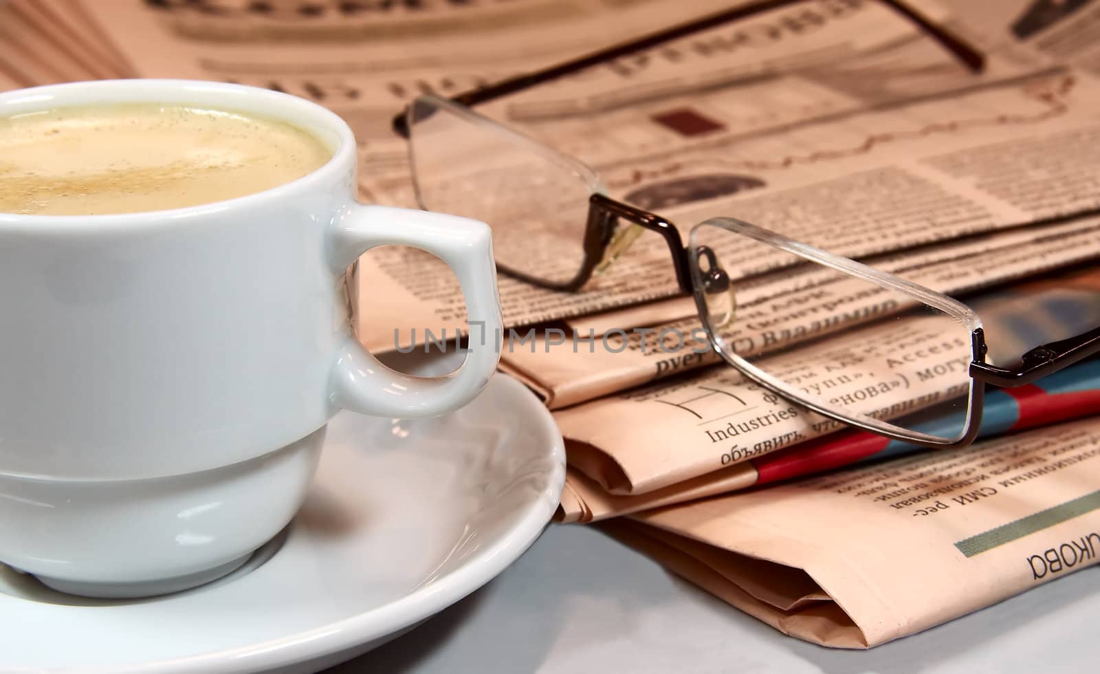 Cup of coffee, newspapers and eyeglasses