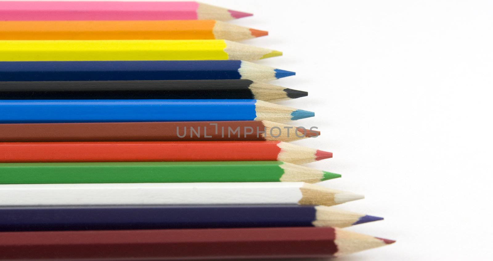 Collection of coloured pencils on white by serpl