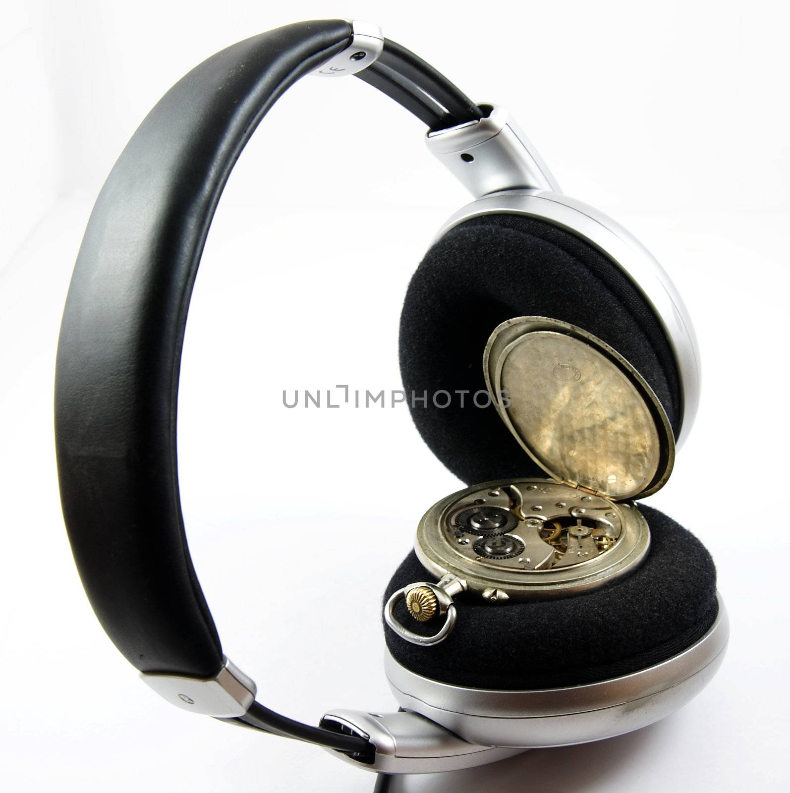 To hear time's melody. Old silver pocket watch in headphones isolated over white background.