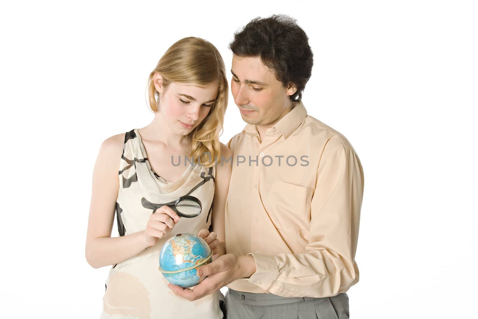 A couple looking at a small globe through a magnifier