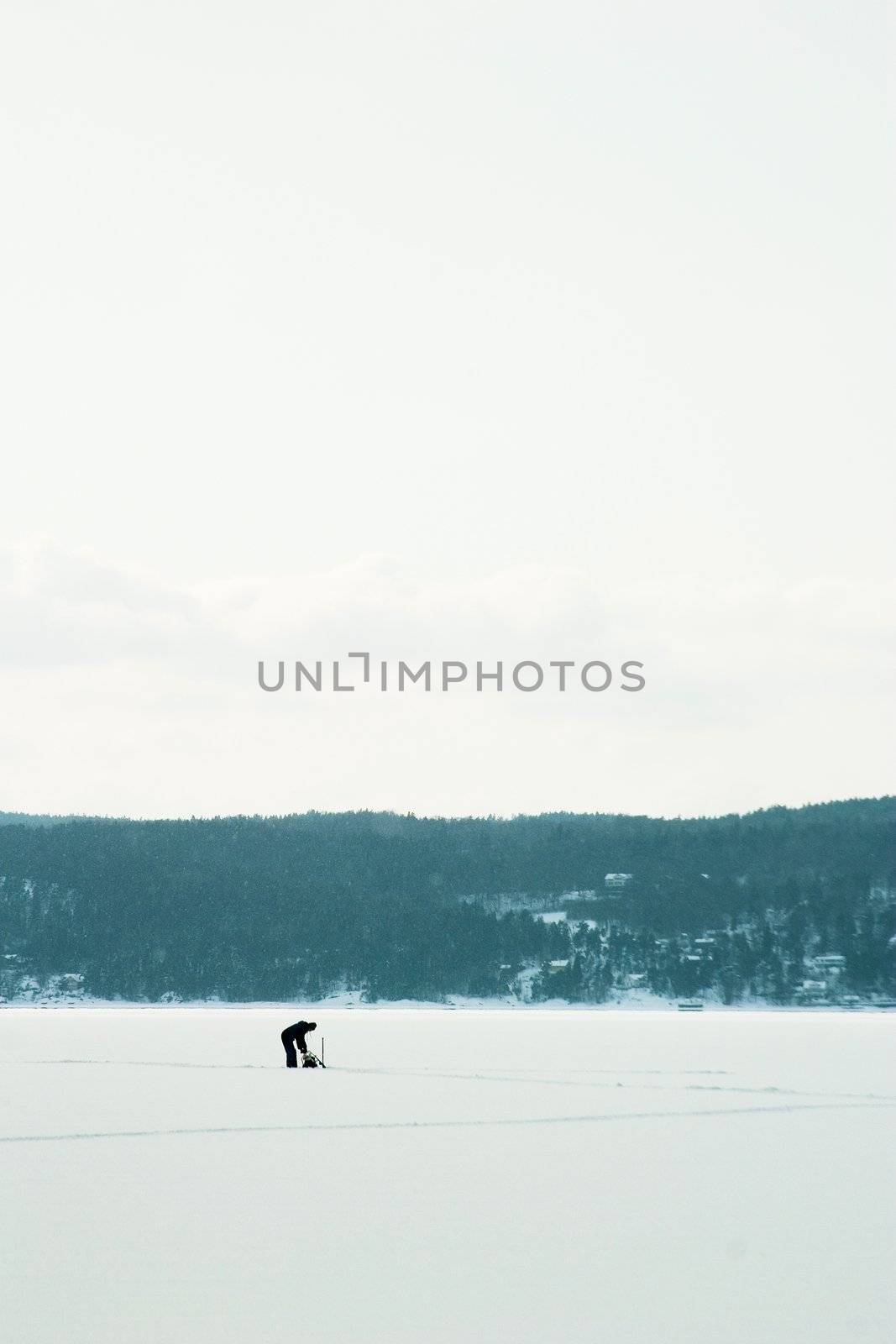 A person Ice fishing on the oslo fjord in early March.