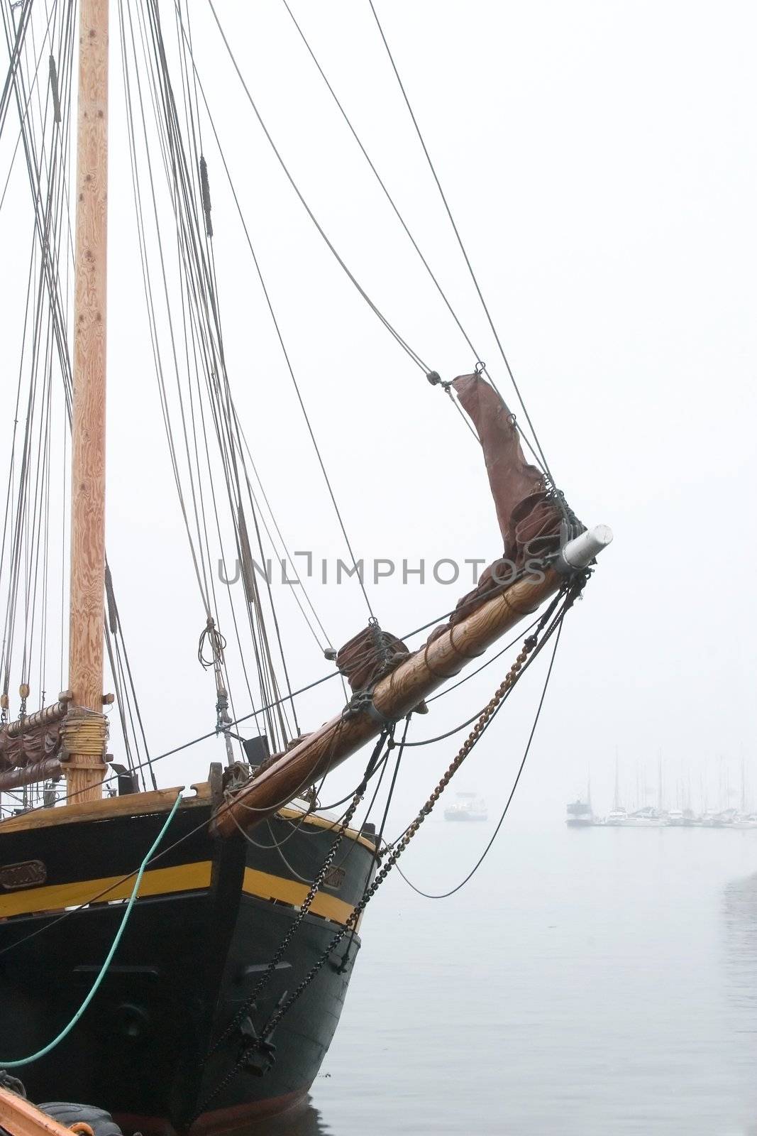 An old wooden sail ship in thick fog.