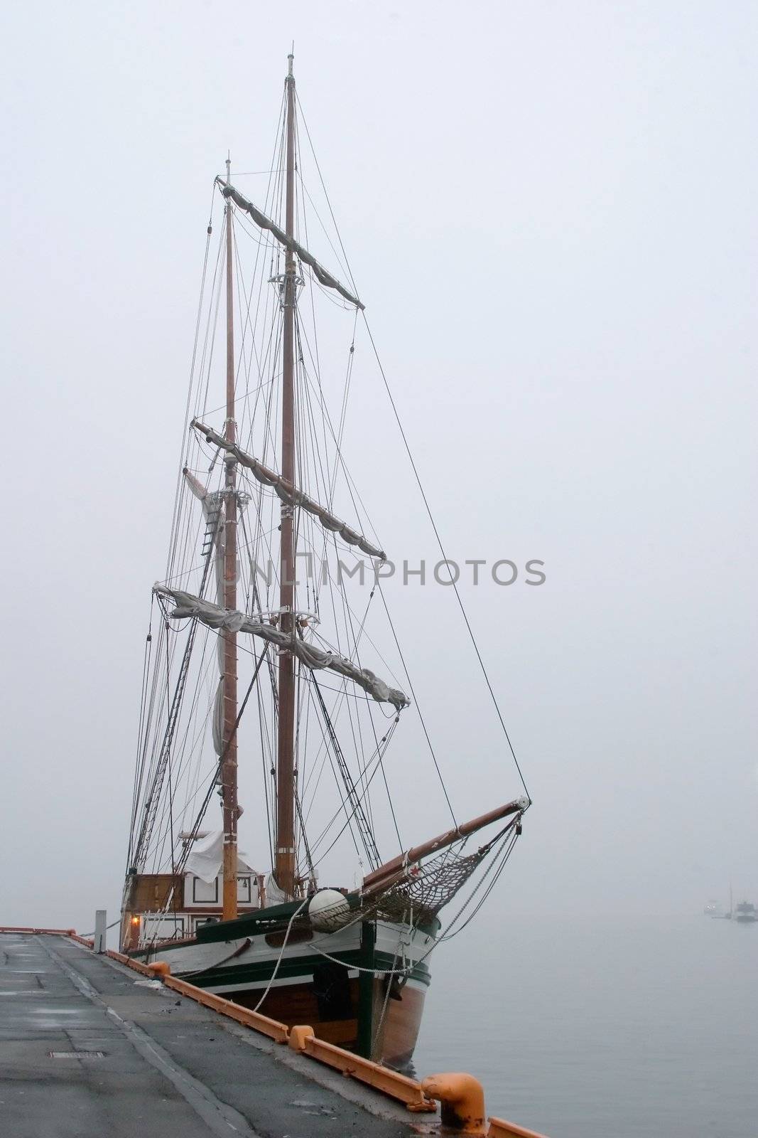 An old wooden sail ship in thick fog.