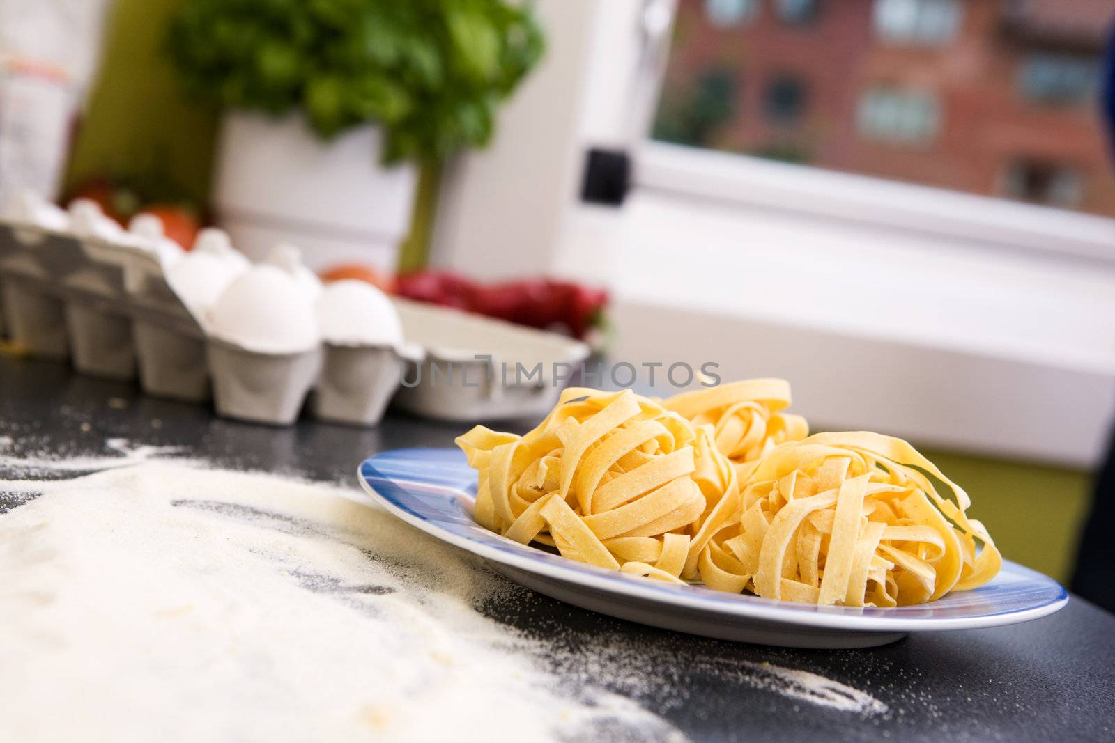 A detail of homemade fettuccine on a plate ready to be boiled