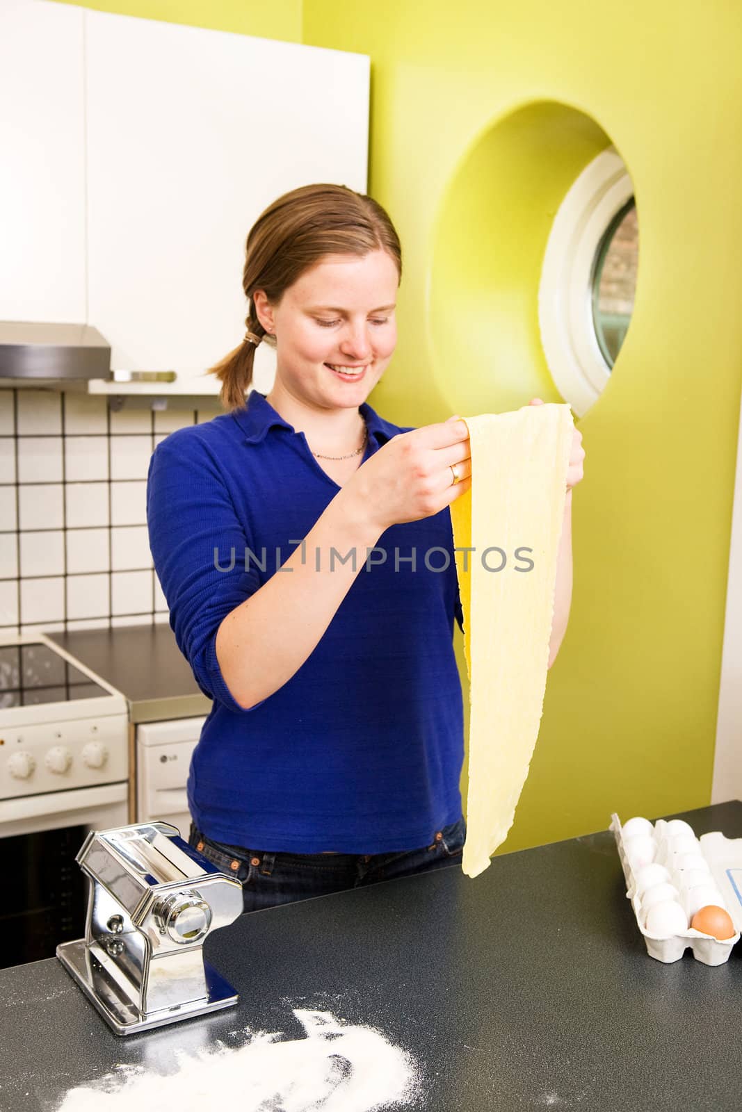 A young woman looks at the pasta she has just made.