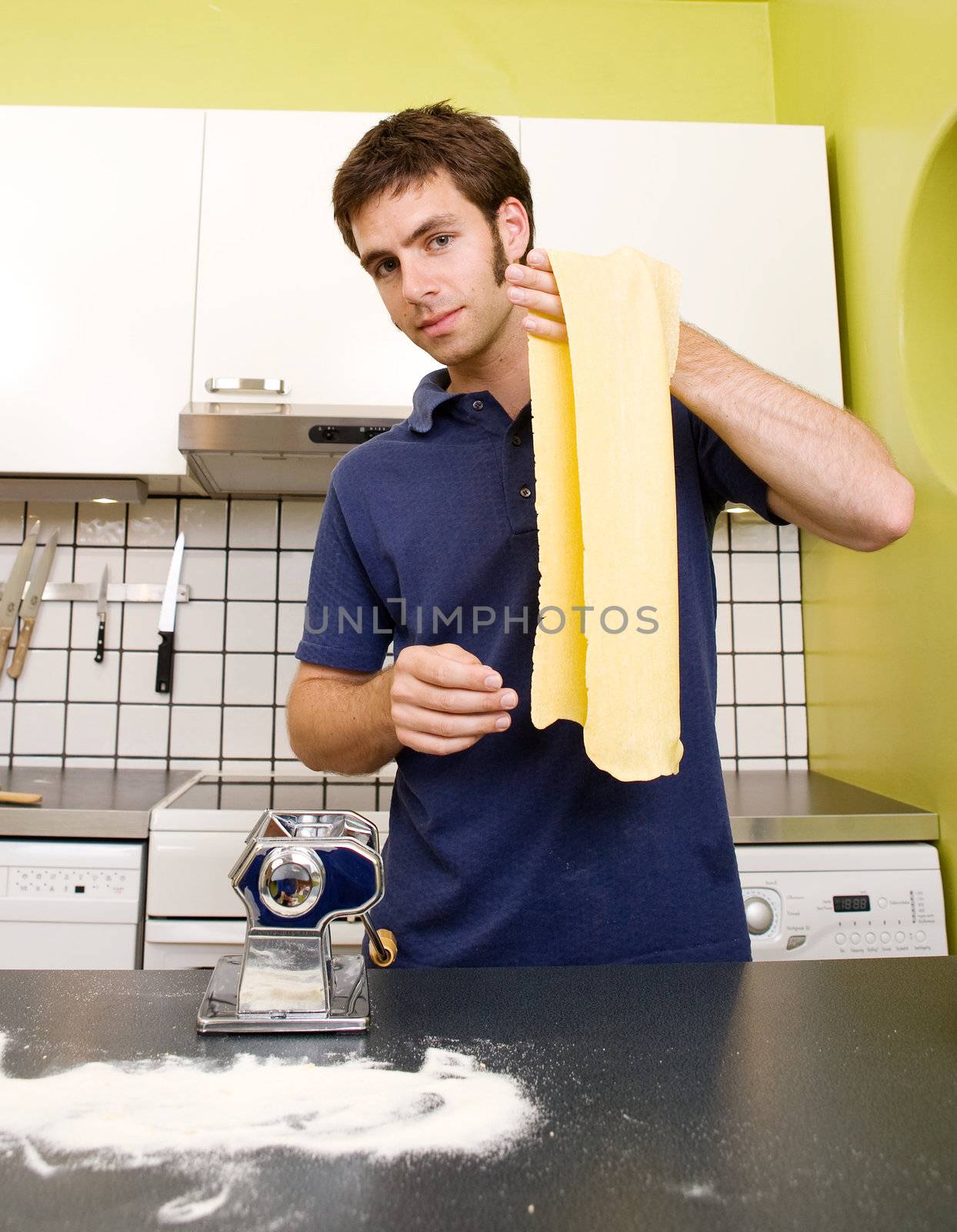 A young male happy and proud over the pasta he has made