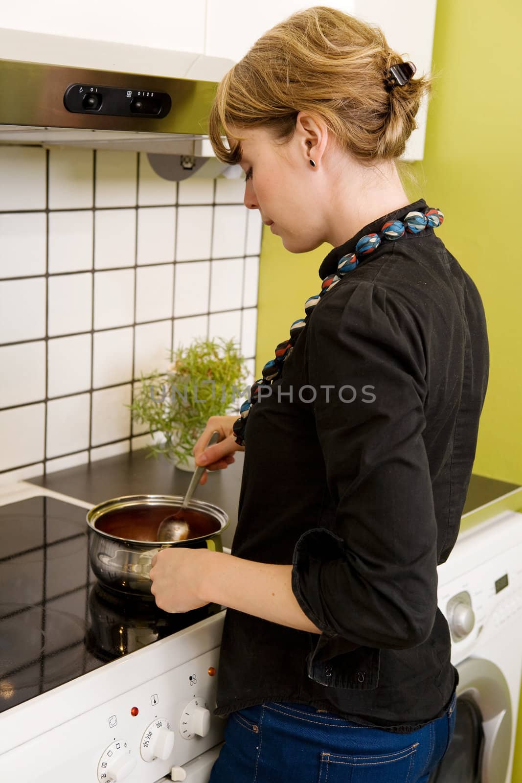 Female Cooking Supper in Kitchen by leaf