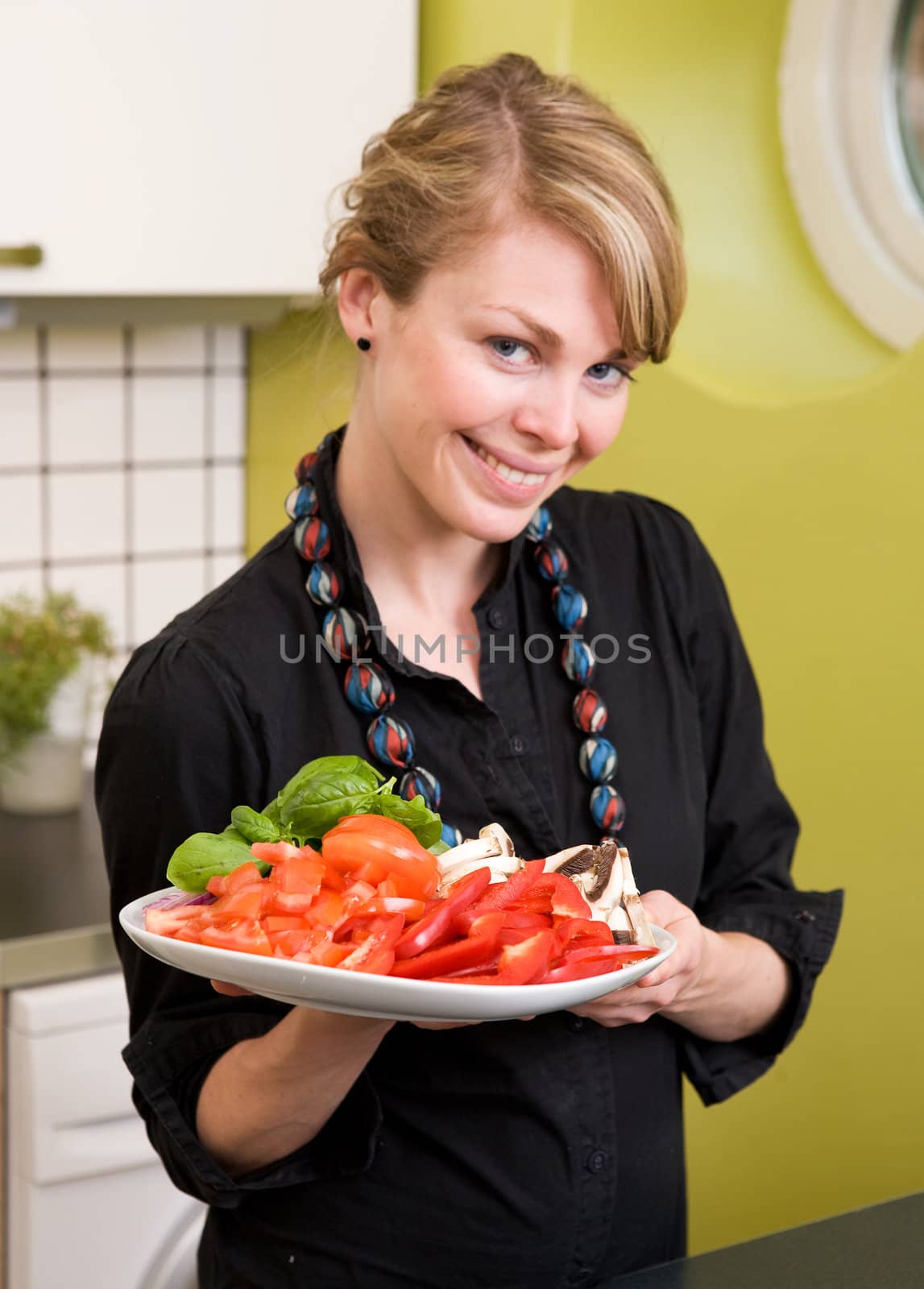 A female in the kitchen looking down on a tasty plate of vegetables