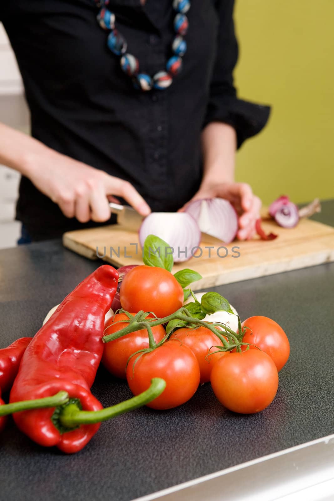 Tomatoes and a Chillie pepper sitting on the couter waiting to be sliced. - Shallow depth of field with ocus is on the vegetables in the foreground of the images.