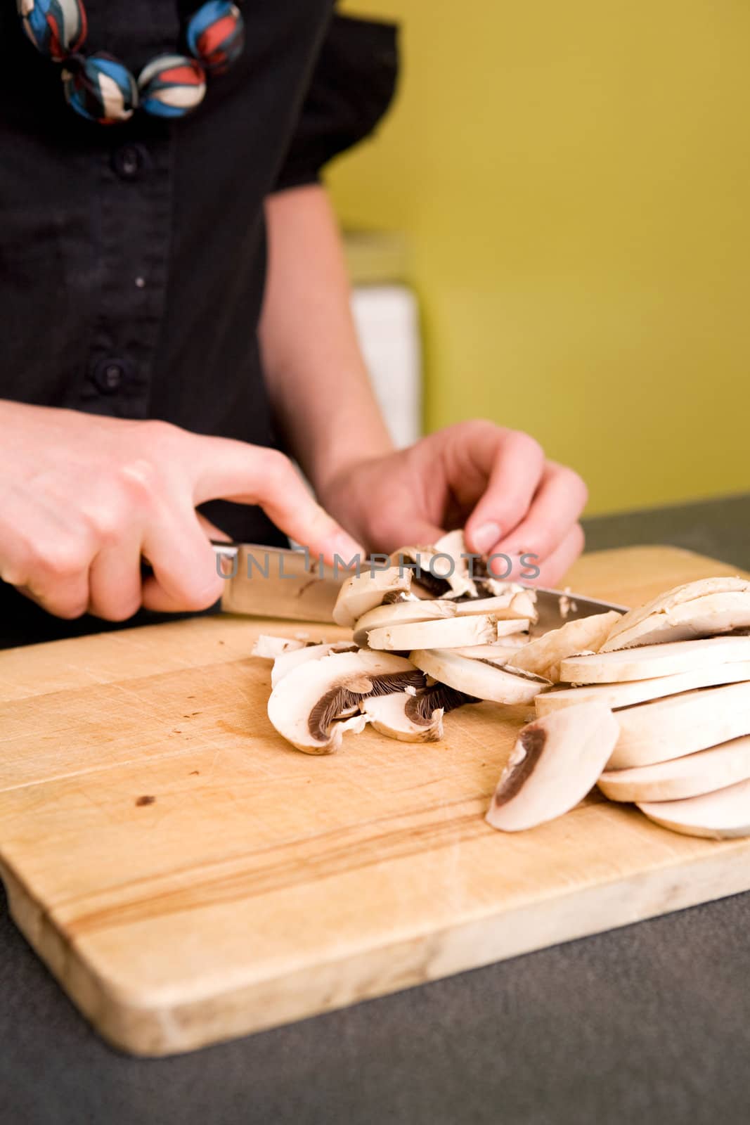A woman cutting mushrooms at home on the counter