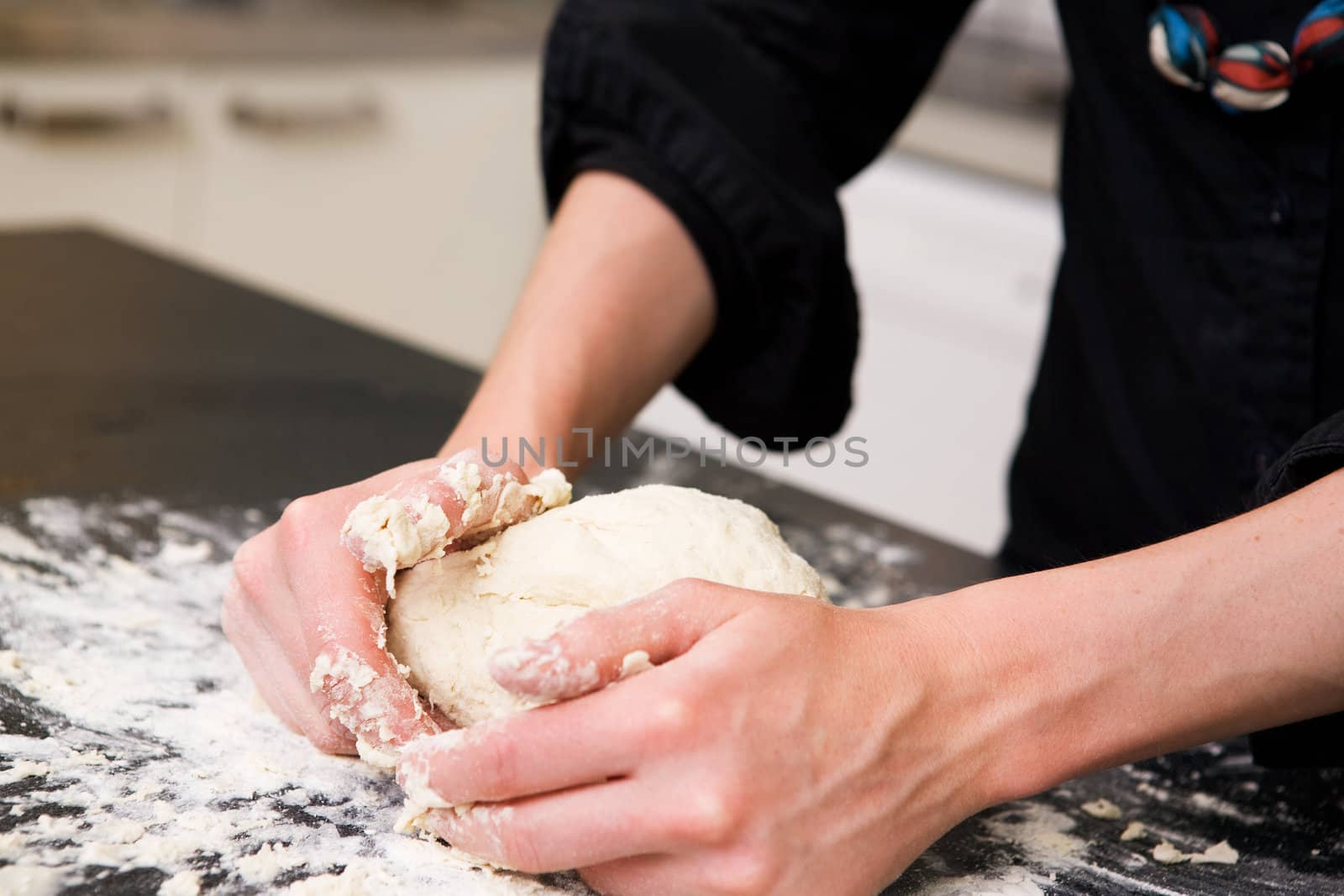 A young woman makes bread on the counter at home in the kitchen.