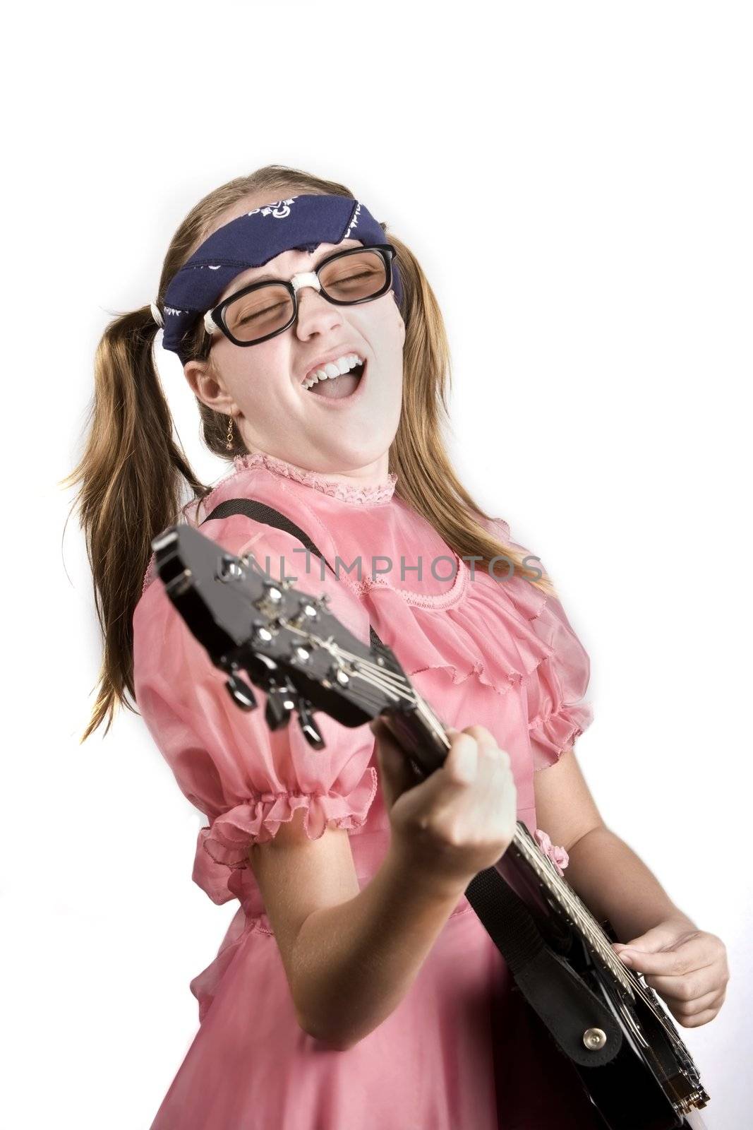 Young girl in a pink dress with an electric rock guitar