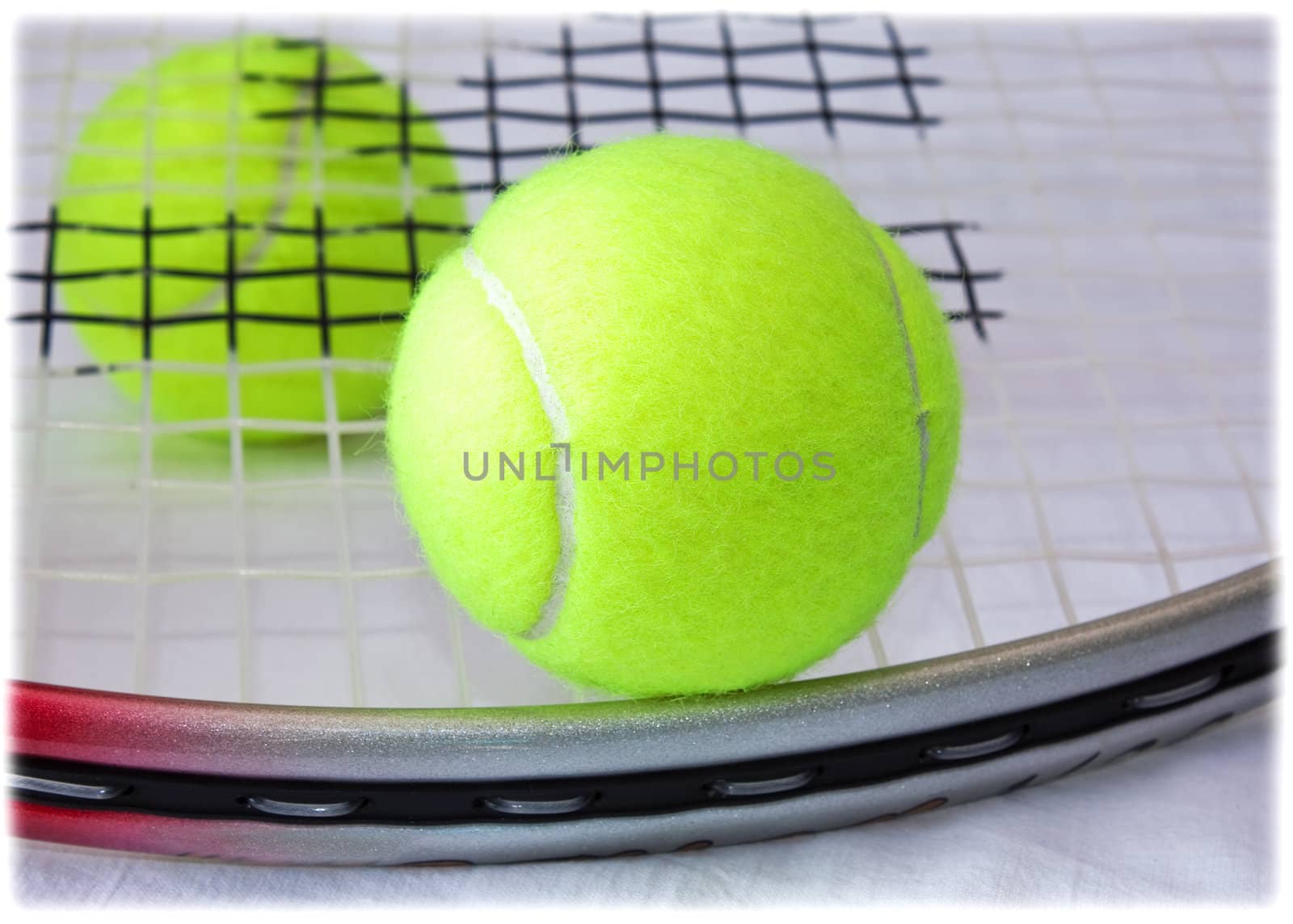 Closeup of tennis racket and two yellow balls