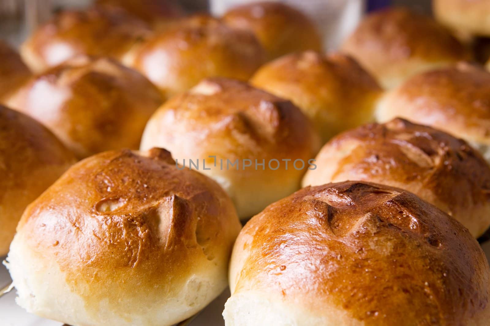 Close up detail of freshly baked hot cross buns in romantic renaissance lighting and a shallow depth of field.