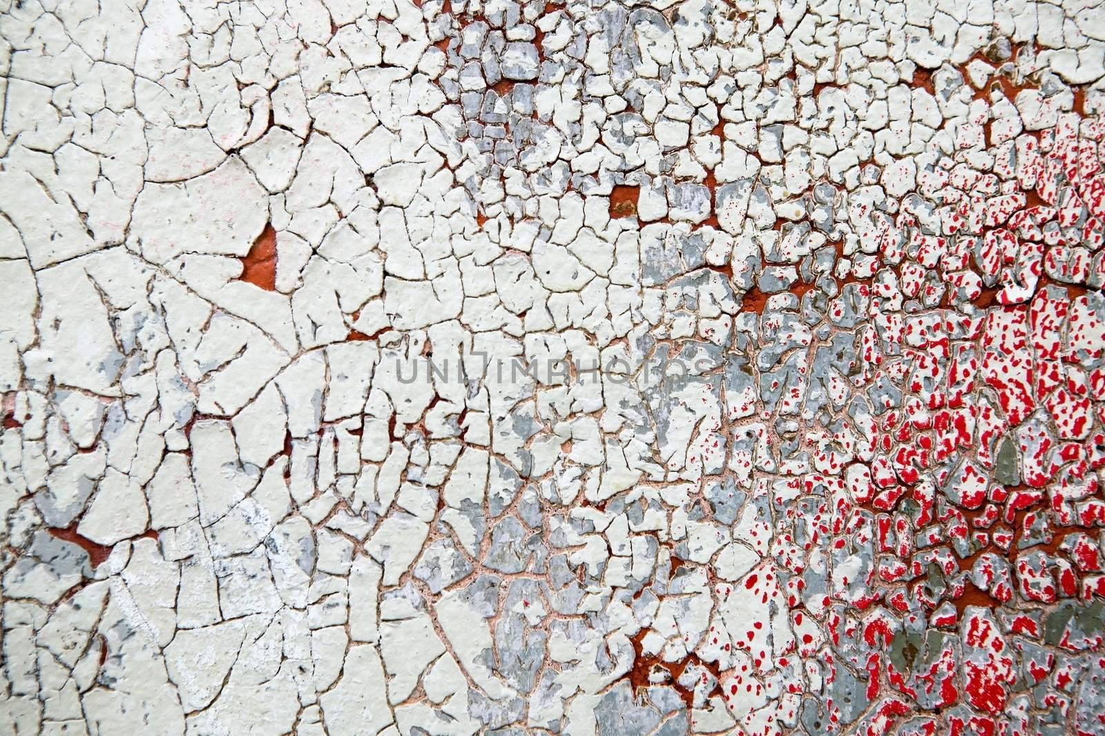 Thick paint and paster slowly peeling off and cracking on an antique wood, brick and plaster building.