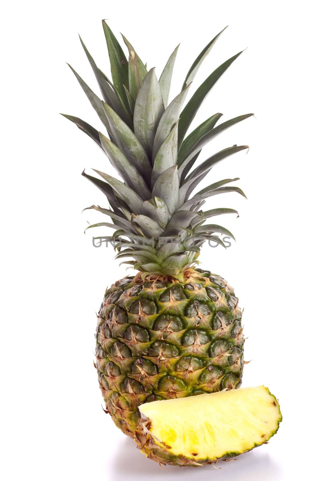 Pineapple with slice in front on white background